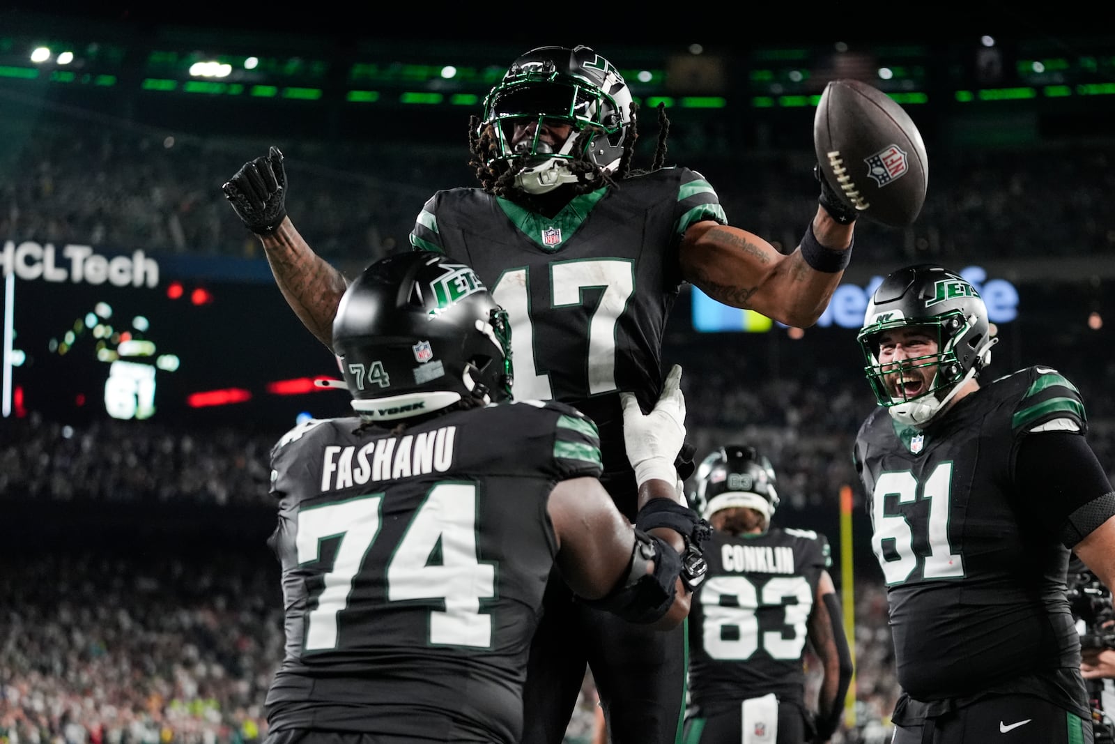 New York Jets offensive tackle Olu Fashanu (74) lifts wide receiver Davante Adams (17) after his touchdown during the second half of an NFL football game against the Houston Texans, Thursday, Oct. 31, 2024, in East Rutherford, N.J. (AP Photo/Frank Franklin II)