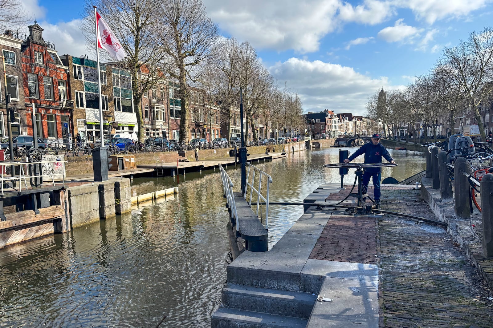 Rashid Ouchene opens the lock in Utrecht, Netherlands, Tuesday, March 11, 2025, where a "fish doorbell" was installed that lets viewers of an online livestream alert authorities to fish being held up as they make their springtime migration to shallow spawning grounds. (AP Photo/Aleksandar Furtula)