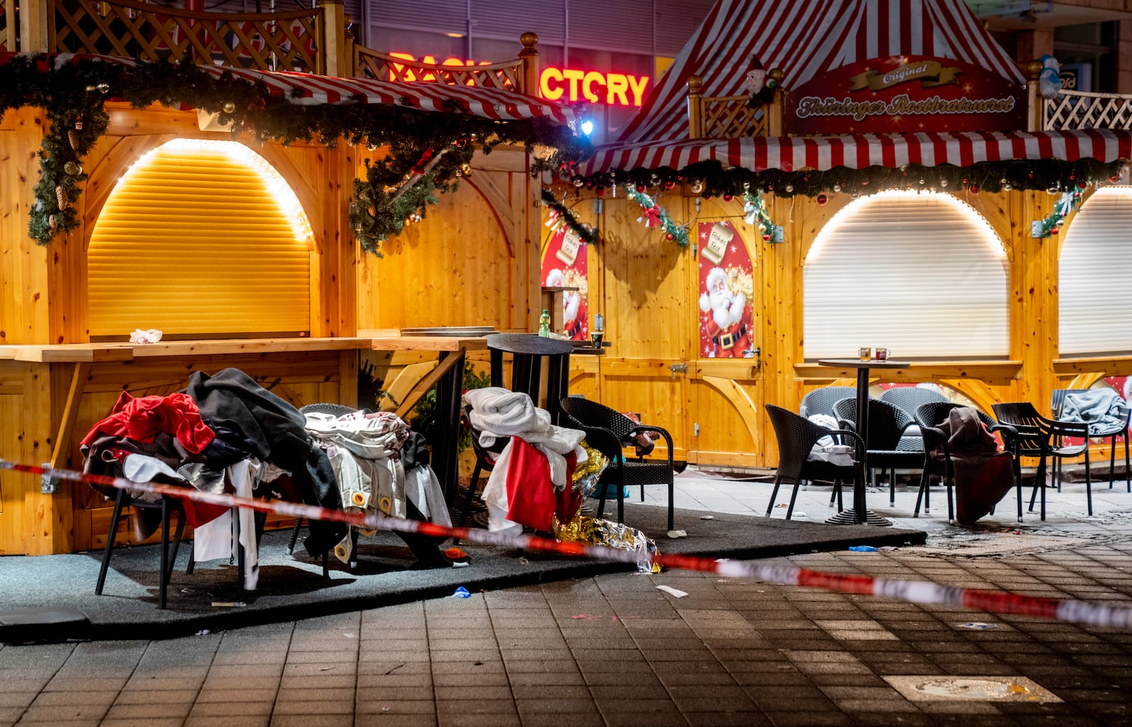 Clothes and blankets lie on chairs at the Christmas market, where a car drove into a crowd on Friday evening, in Magdeburg, Germany, Sunday, Dec. 22, 2024. (AP Photo/Michael Probst)