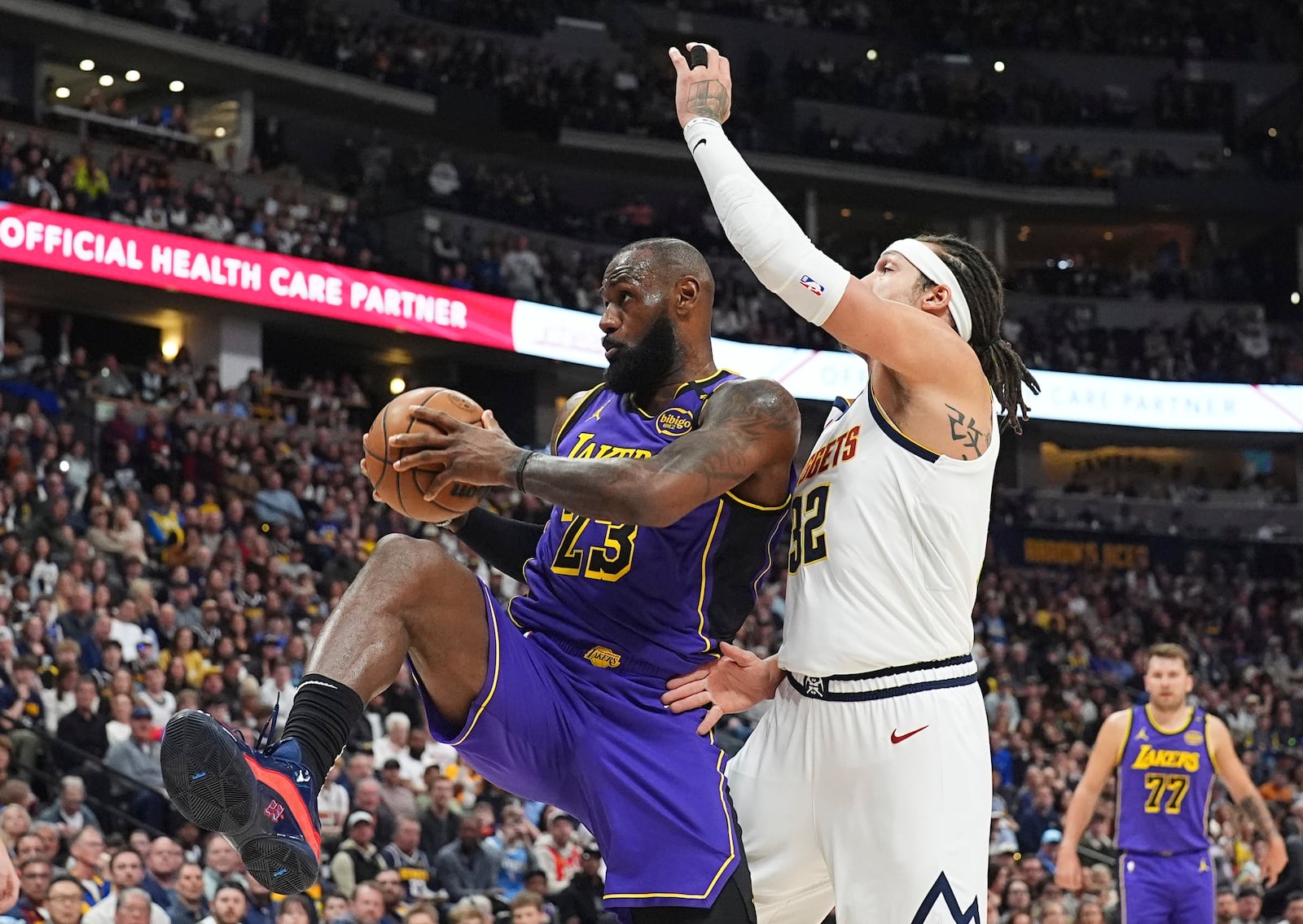 Los Angeles Lakers forward LeBron James, left, pulls in a rebound as Denver Nuggets forward Aaron Gordon defends in the first half of an NBA basketball game Saturday, Feb. 22, 2025, in Denver. (AP Photo/David Zalubowski)