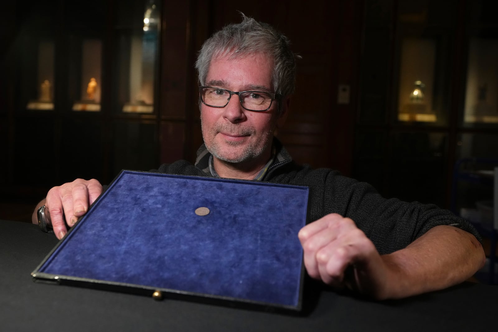 Malcolm Weale, detectorist who found the item displays an early medieval silver penny of Guthrum of East Anglia, the first silver coin minted by a Viking ruler in Britain, at the British Museum's annual treasure launch in London, Tuesday, Feb. 11, 2025. (AP Photo/Kirsty Wigglesworth)