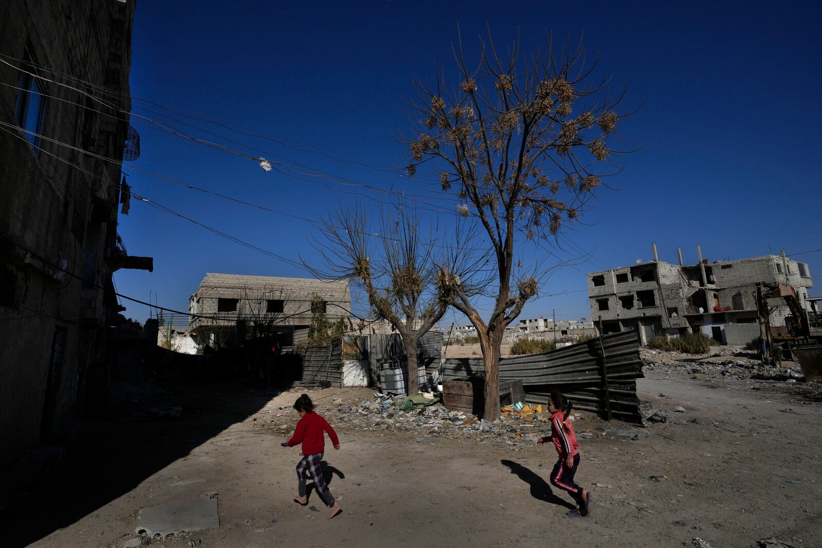 Syrian girls plays at an alley that was hit by the sarin struck during a 2013 chemical weapons attack that was blamed on then President Bashar Assad's forces, in Zamalka neighbourhood, on the outskirts of Damascus, Syria, Wednesday, Dec. 25, 2024. (AP Photo/Hussein Malla)