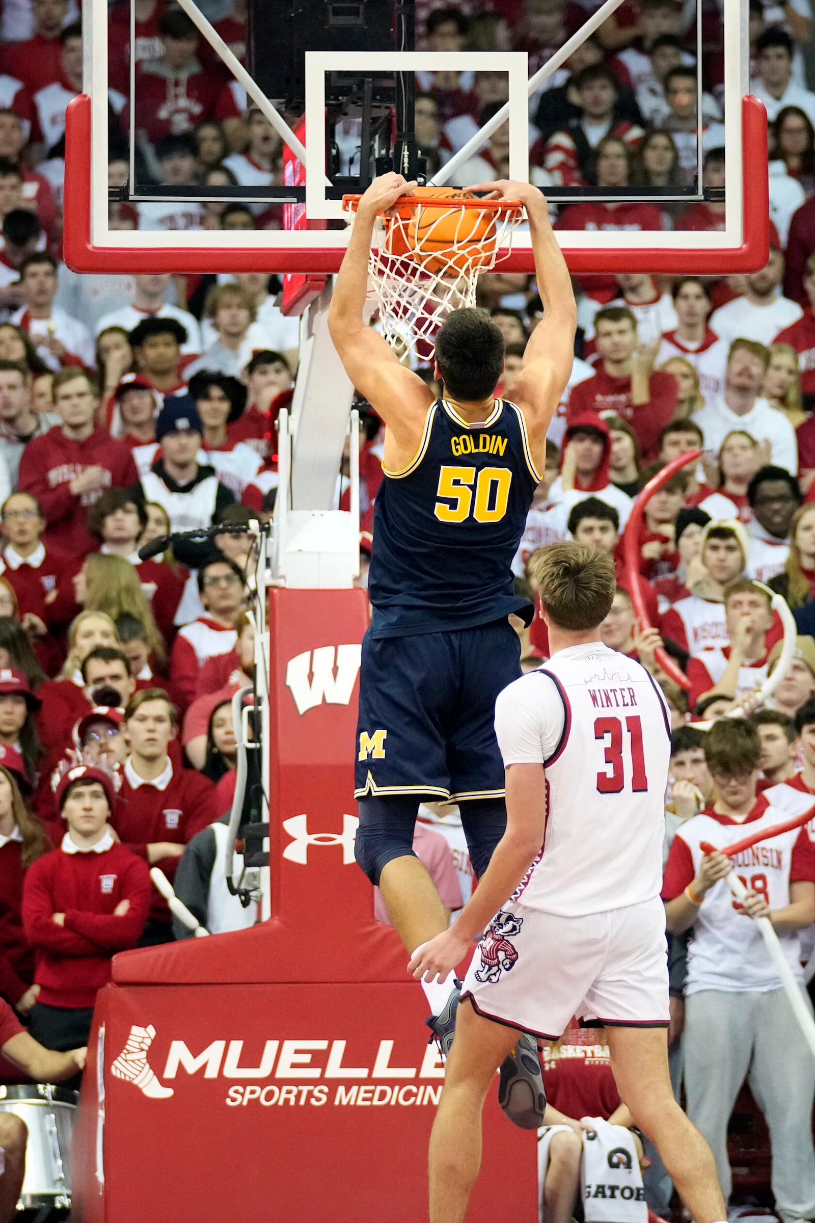 Michigan center Vlad Goldin (50) dunks the ball during the second half of an NCAA college basketball game against Wisconsin Tuesday, Dec. 3, 2024, in Madison, Wis. Michigan won 67-64. (AP Photo/Kayla Wolf)