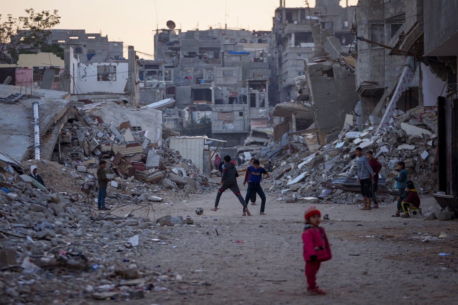 Palestinian children play next to buildings destroyed by Israeli army strikes in Khan Younis, Gaza Strip, Tuesday, Jan. 7, 2025. (AP Photo/Abdel Kareem Hana)