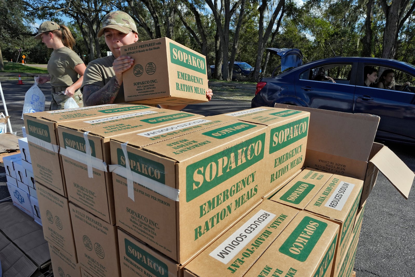 Members of the Florida Air National Guard load supplies into residents cars displaced by Hurricane Milton, Sunday, Oct. 13, 2024, at the Hillsborough Community College campus in Brandon, Fla. (AP Photo/Chris O'Meara)