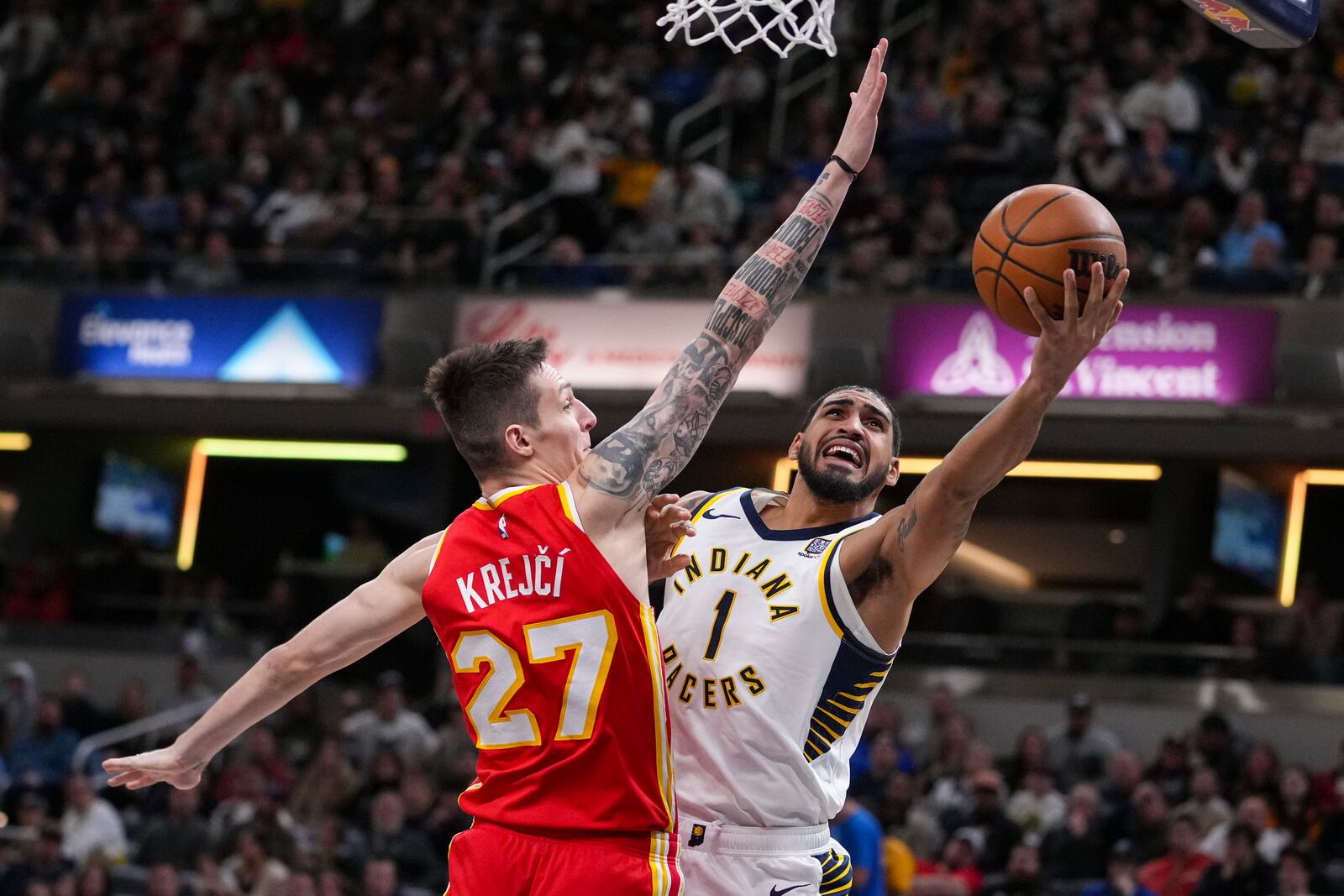 Indiana Pacers forward Obi Toppin (1) shoots around Atlanta Hawks guard Vit Krejci (27) during the second half of an NBA basketball game in Indianapolis, Saturday, Feb. 1, 2025. (AP Photo/Michael Conroy)