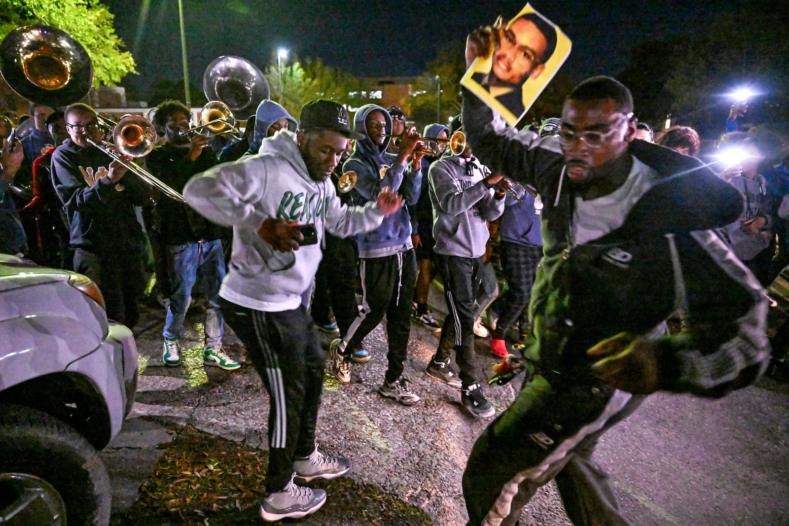 Mourners dance while holding up pictures of Caleb Wilson as a second line marches through campus after a vigil for Wilson was held outside of Southern University's Smith-Brown Student Union on Wednesday, March 5, 2025, in Baton Rouge, La. (Javier Gallegos/The Advocate via AP)