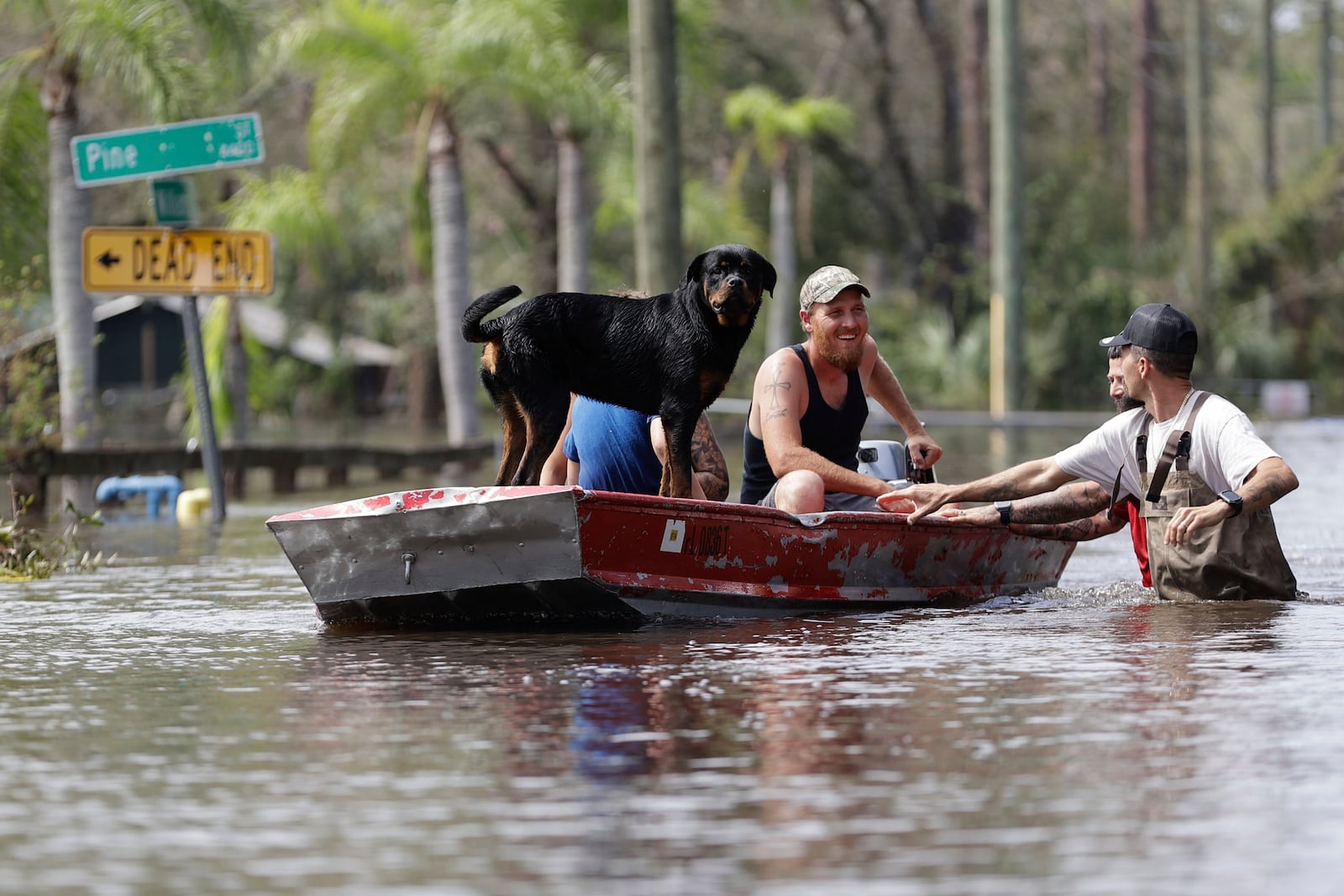 Residents ride in a boat in a neighborhood inundated by historic flooding of the Alafia River caused by Hurricane Milton on Friday, Oct. 11, 2024 in Lithia, Fla. (Luis Santana/Tampa Bay Times via AP)