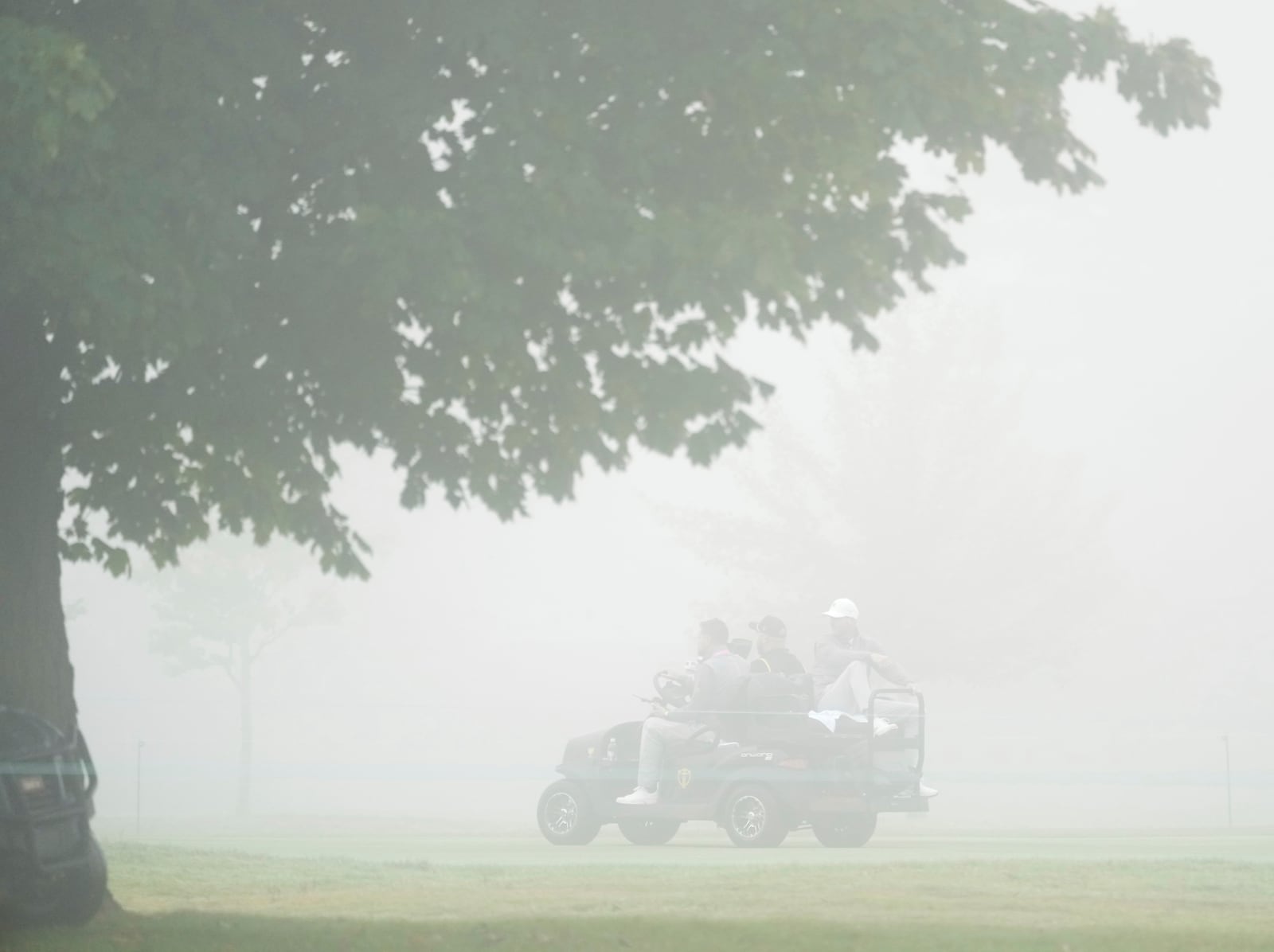 International team members Adam Scott, of Australia, and Taylor Pendrith, of Canada, head back to the clubhouse from the first hole after play was suspended due to fog at the Presidents Cup golf tournament at Royal Montreal Golf Club in Montreal Saturday, Sept. 28, 2024. (Christinne Muschi/The Canadian Press via AP)