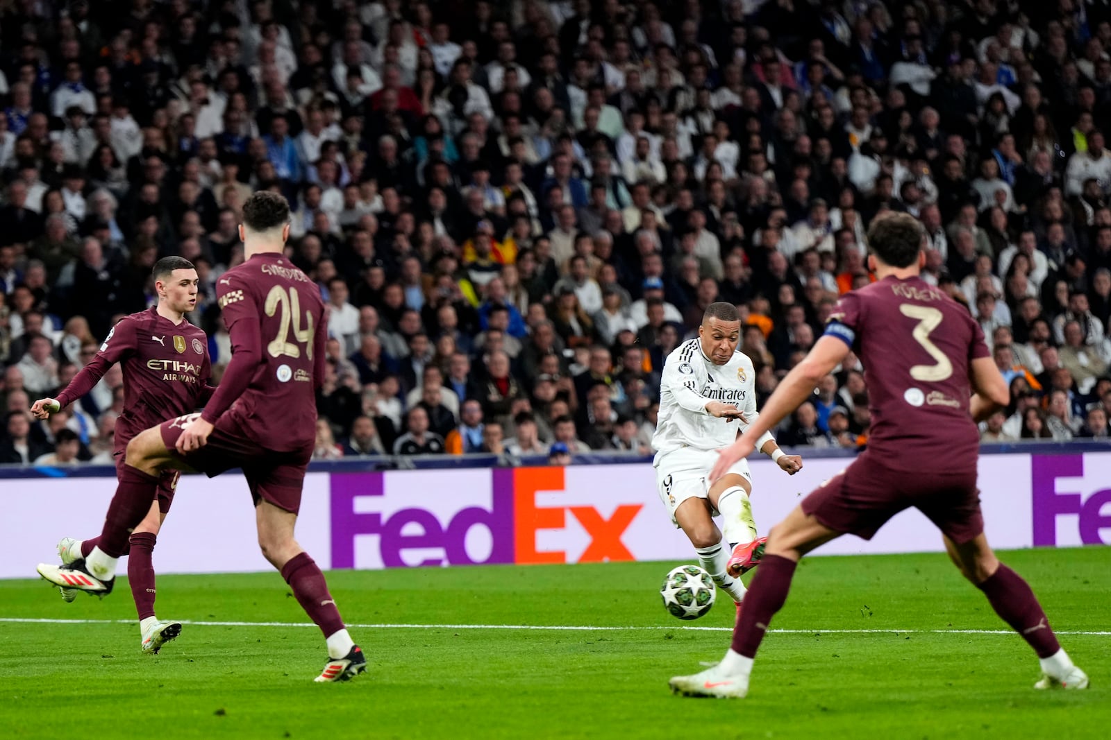 Real Madrid's Kylian Mbappe shoots to score his sides third goal during the Champions League playoff second leg soccer match between Real Madrid and Manchester City at the Santiago Bernabeu Stadium in Madrid, Spain, Wednesday, Feb. 19, 2025. (AP Photo/Manu Fernandez)