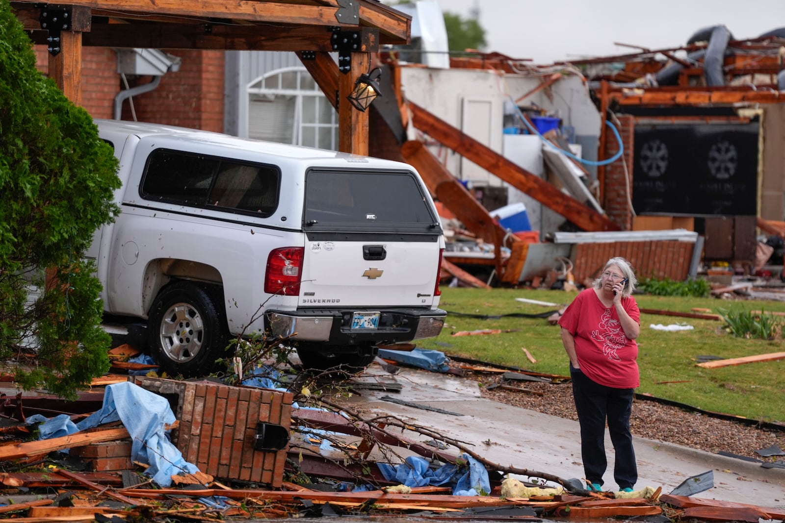 A women stands outside a damaged home after a tornado hit the area in Oklahoma City, Sunday, Nov. 3, 2024. (Bryan Terry/The Oklahoman via AP)