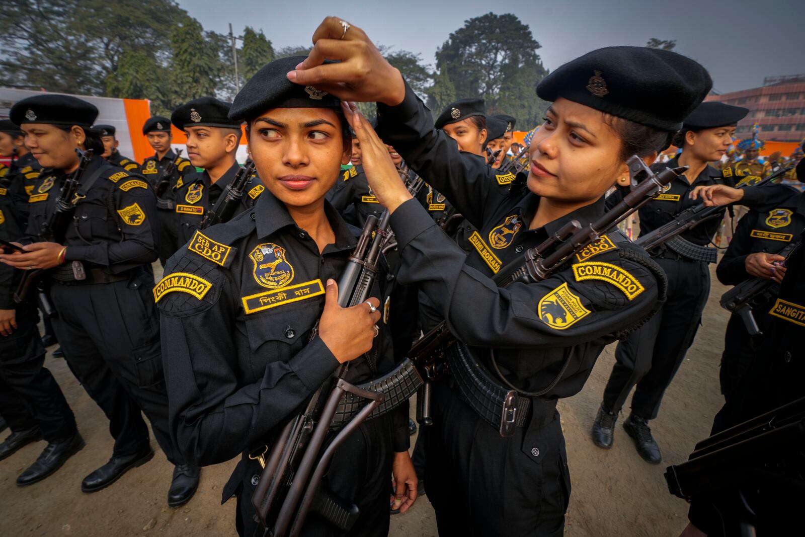 An Assam police woman commando adjusts a cap for another commando before marching during India's Republic Day parade in Guwahati, India, Sunday, Jan. 26, 2025. (AP Photo/Anupam Nath)