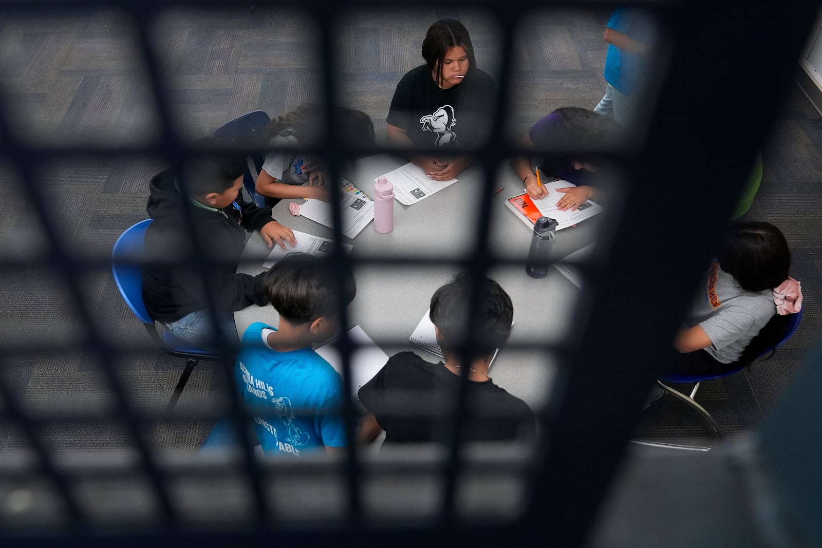 Alisson Ramírez, top center, watches as classmates collaborate on a math worksheet Wednesday, Aug. 28, 2024, in Aurora, Colo. (AP Photo/Godofredo A. Vásquez)