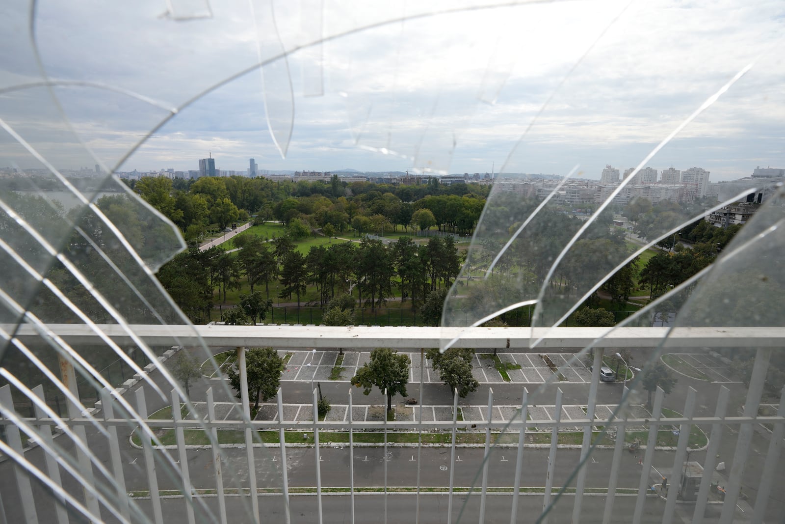 A general view of Belgrade is partially seen through the broken window from Hotel Yugoslavia, once a symbol of progress in the former socialist state of Yugoslavia that broke apart in the 1990s and a favorite gathering place for local residents as well as world leaders, in Belgrade, Serbia, Thursday, Oct. 3, 2024. (AP Photo/Darko Vojinovic)