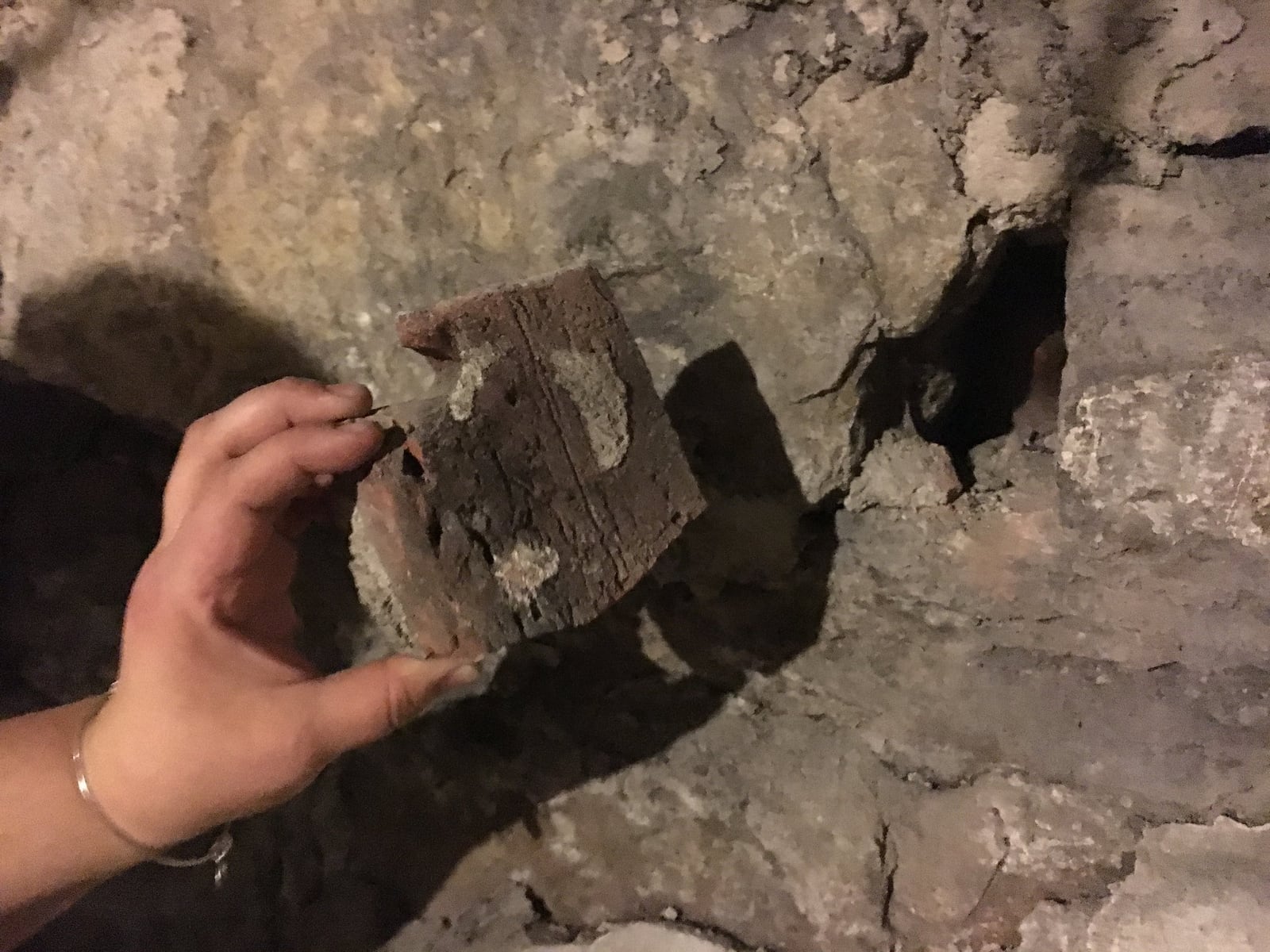 The loose brick in the basement of West Central Wine where a note written nearly 60 years ago was found.