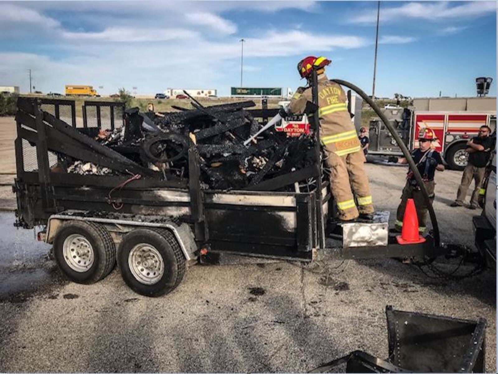 Dayton fire crews put water on items that caught fire as they were being hauled on I-75 South in Dayton on Friday afternoon. (Jim Noelker/Staff)