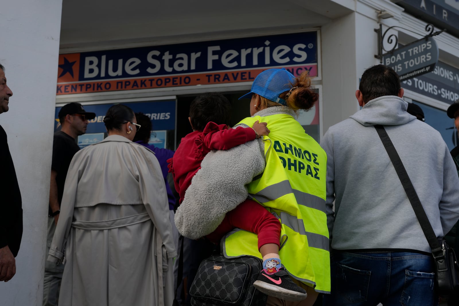 People wait to buy boat and air tickets as Greek authorities are taking emergency measures in response to intense seismic activity on the popular Aegean Sea holiday island of Santorini, southern Greece, Monday, Feb. 3, 2025. (AP Photo/Petros Giannakouris)