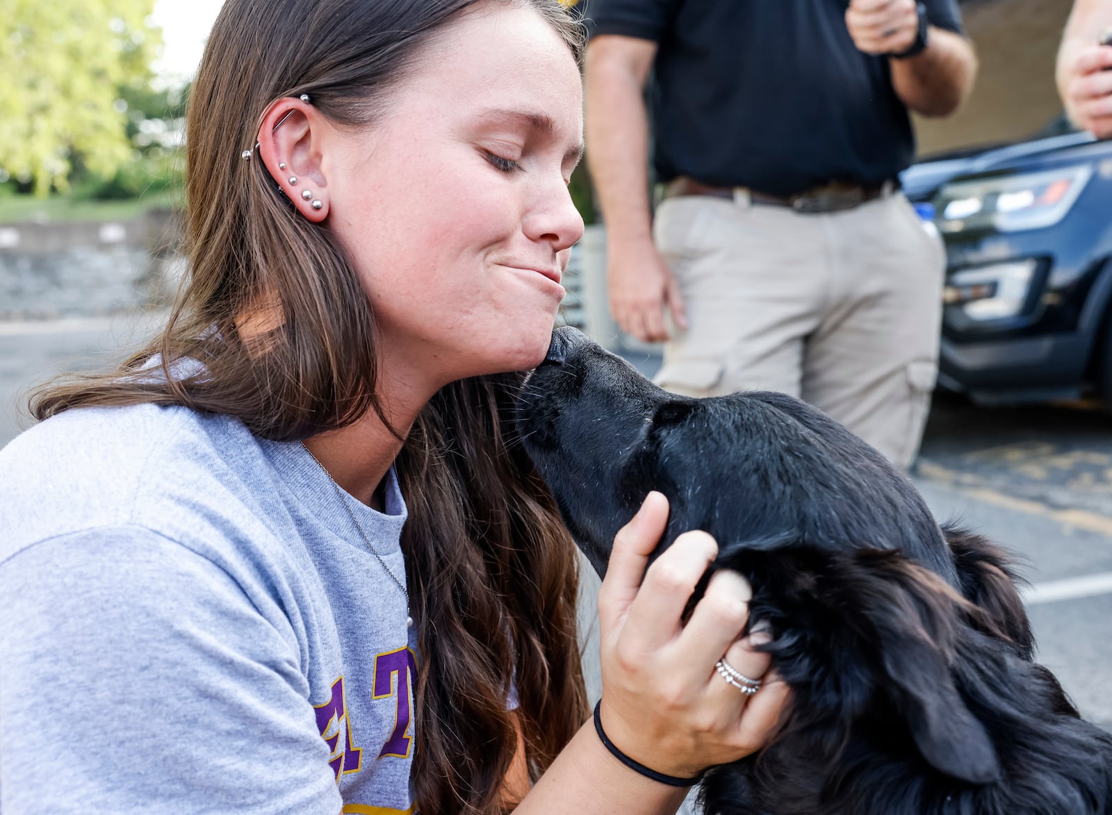 Emma Hiatt pets, Arthur, one of two new therapy dogs for Hamilton Police Department Thursday, Aug. 3, 2023. Hiatt is the sister of Arthur's handler, officer Jake Hiatt. NICK GRAHAM/STAFF