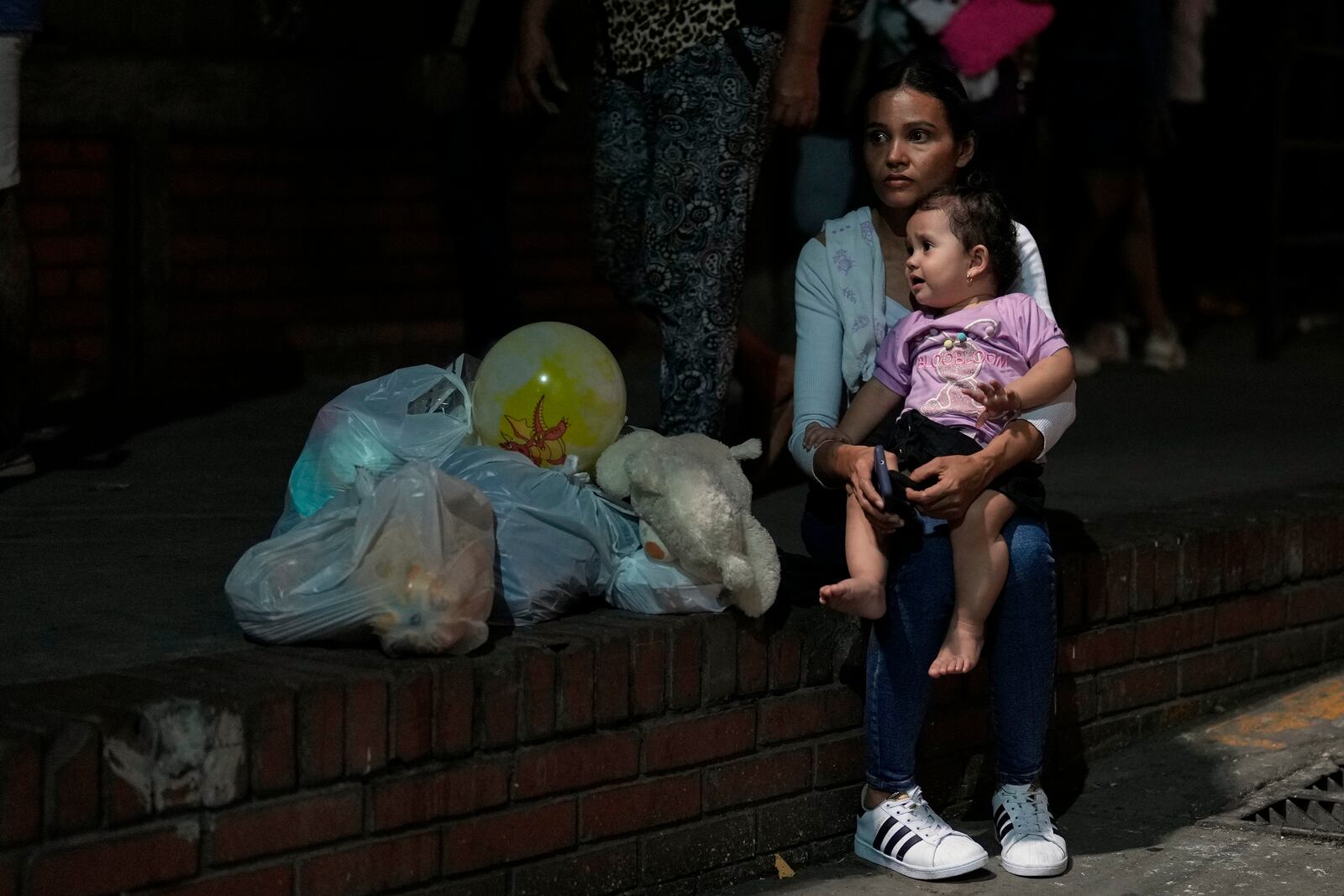 People displaced by violence in towns across the Catatumbo region, where rebels of the National Liberation Army, or ELN, have been clashing with former members of the Revolutionary Armed Forces of Colombia, arrive at a soccer stadium to take shelter in Cúcuta, Colombia, Sunday, Jan. 19, 2025. (AP Photo/Fernando Vergara)