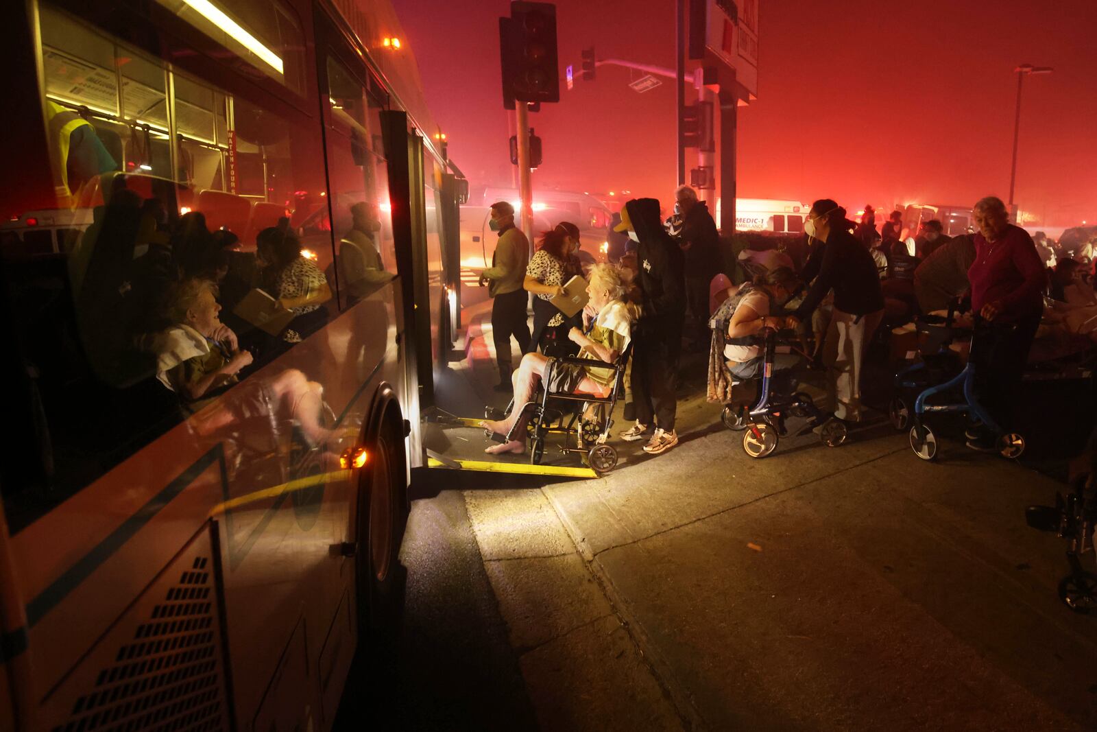 Residents of a senior center are evacuated and loaded into a bus as the Eaton Fire approaches Tuesday, Jan. 7, 2025 in Altadena, Calif. (AP Photo/Ethan Swope)