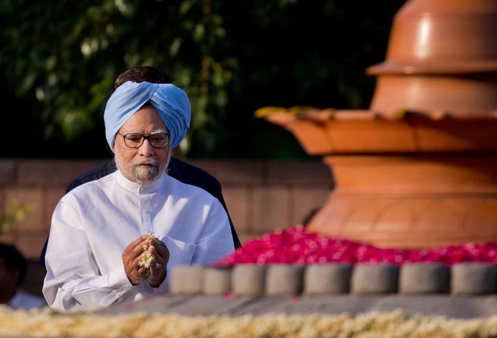 FILE - Former Indian Prime Minister Manmohan Singh pays homage to former prime minister Rajiv Gandhi on his death anniversary in New Delhi, India, Thursday, May 21, 2015. (AP Photo/Saurabh Das, File)