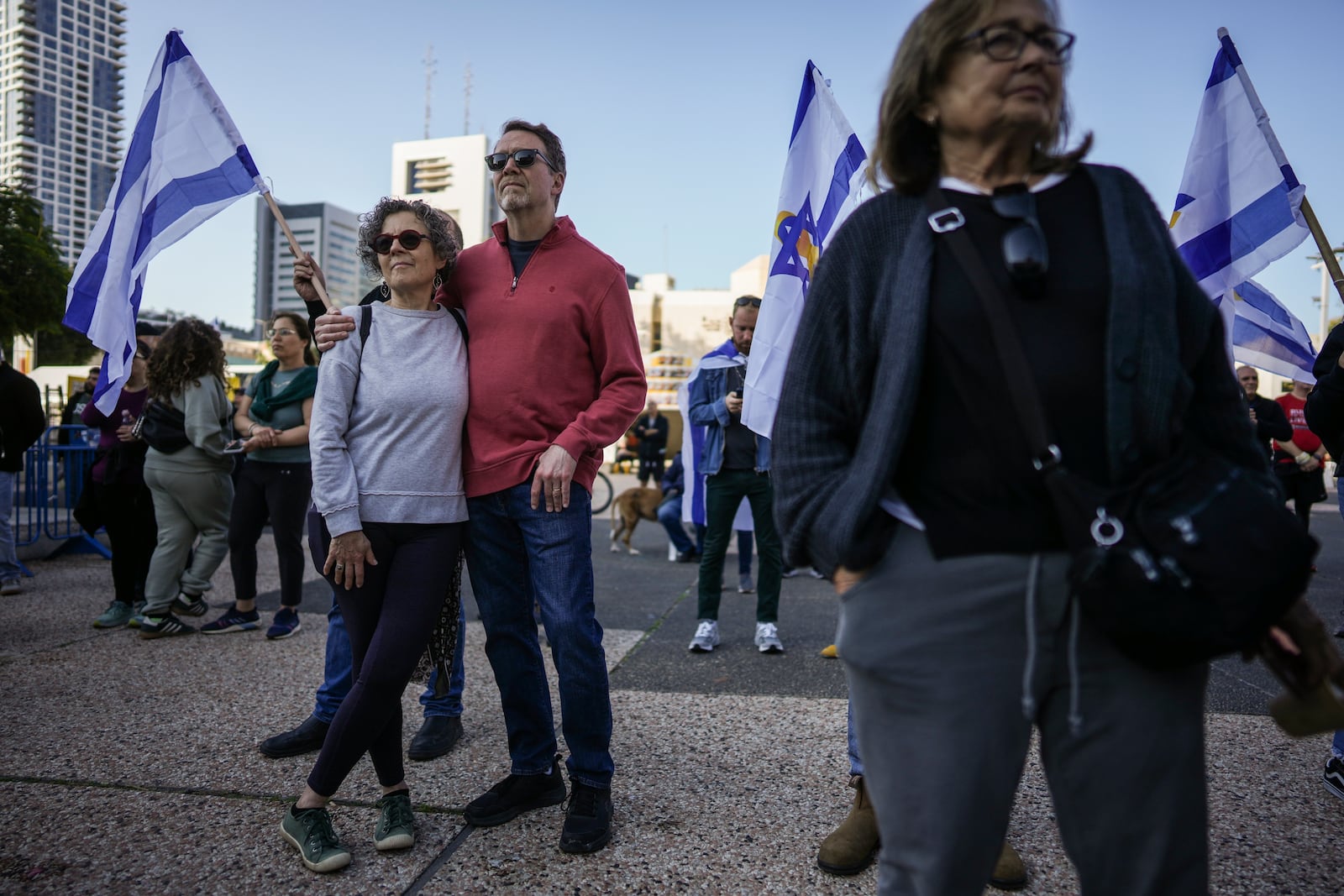 Israelis watch a broadcast of the release of Israelis Ofer Kalderon, 53, and Yarden Bibas, 34, and American-Israeli Keith Siegel, 65 set to be released as part of a ceasefire in the Gaza Strip, in Tel Aviv, Israel, Saturday Feb. 1, 2025. (AP Photo/Oded Balilty)