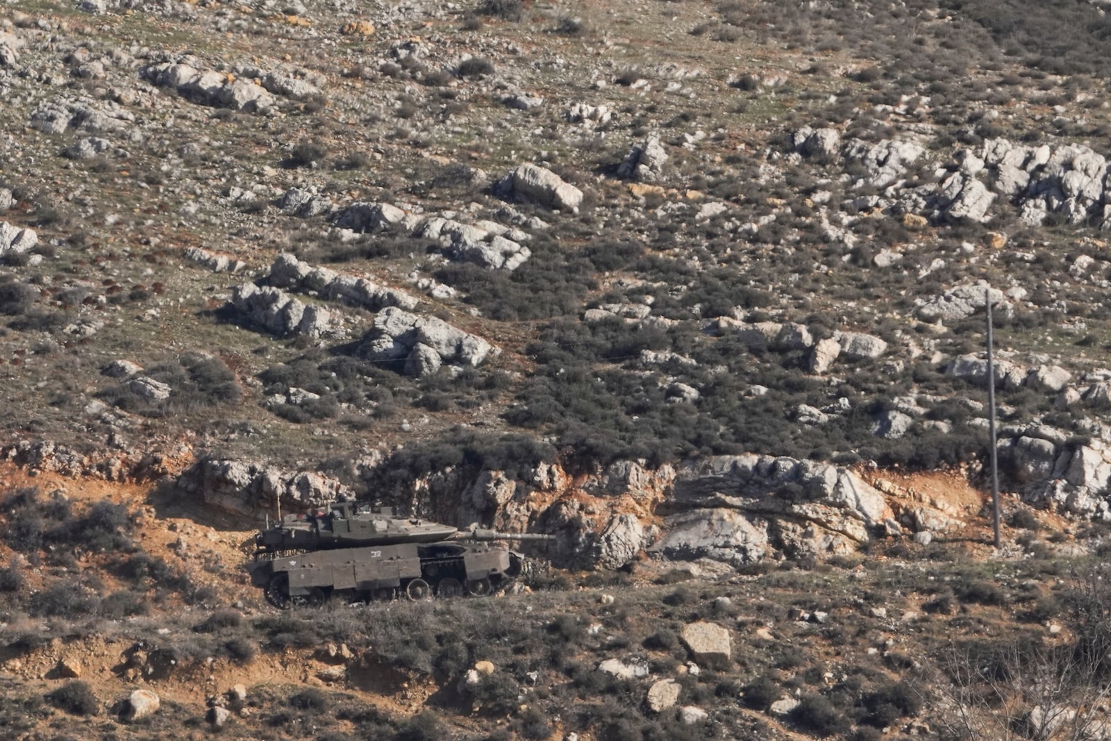 An Israeli tank maneuvers on the buffer zone near the so-called Alpha Line that separates the Israeli-controlled Golan Heights from Syria, viewed from the town of Majdal Shams, Friday, Dec. 20, 2024. (AP Photo/Matias Delacroix)