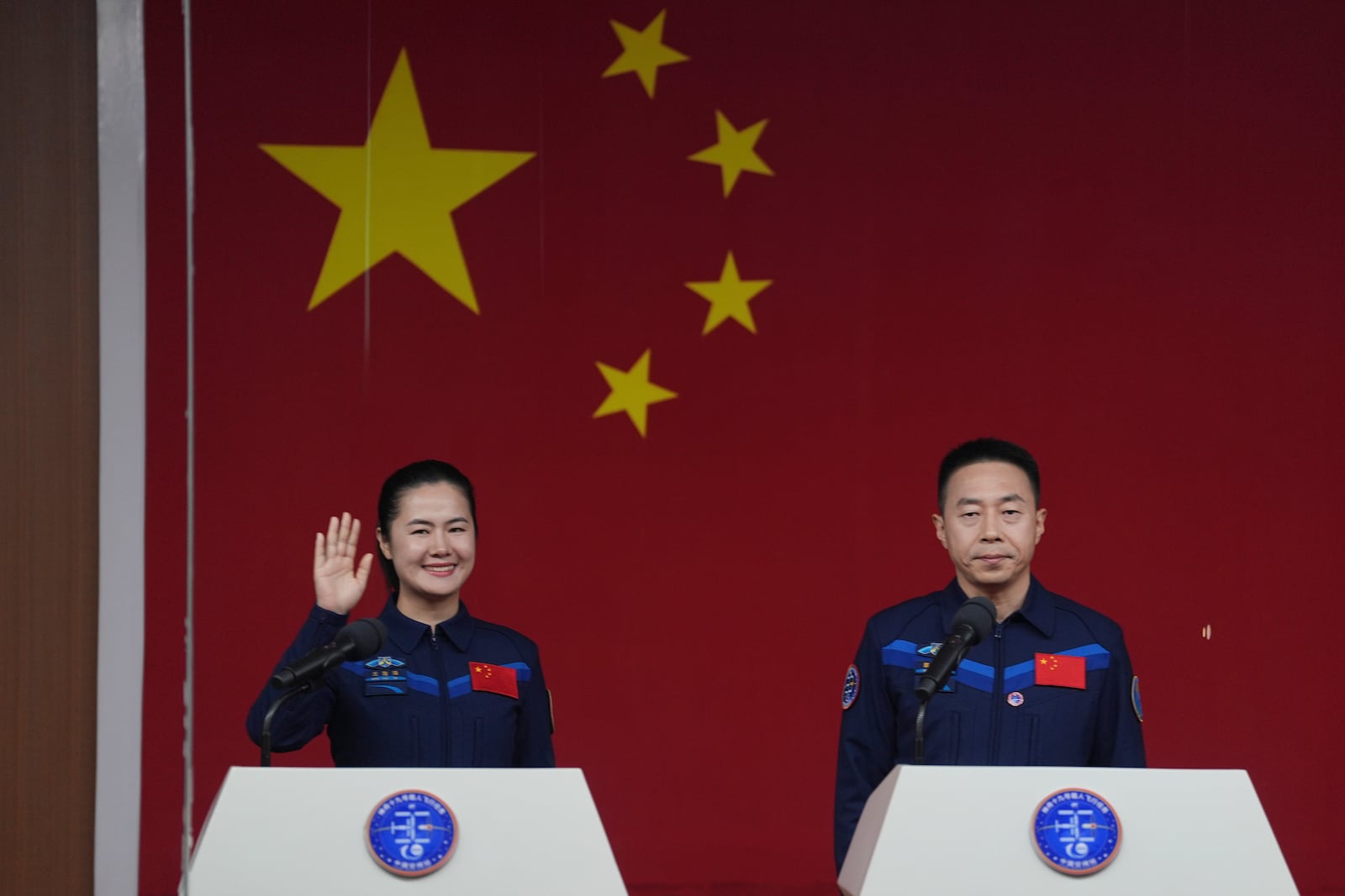 Chinese astronauts Wang Haoze, left, waves near Cai Xuzhe as they meet the press ahead of the Shenzhou-19 mission at the Jiuquan Satellite Launch Center in Jiuquan, northwestern China Tuesday, Oct. 29, 2024. (AP Photo/Ng Han Guan)