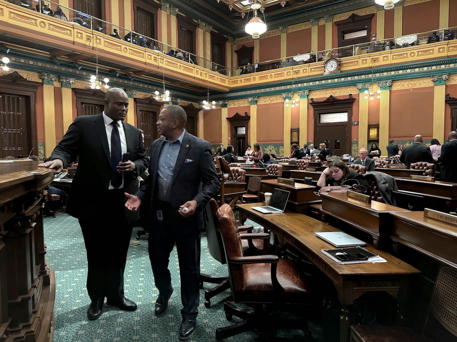 Michigan House Democratic Speaker Joe Tate, left, and state Representative Tyrone Carter, a Democrat, speak on the floor of the Michigan House of Representatives in Lansing, Mich., Thursday, Dec. 19, 2024. Internal divisions caused House Democrats to effectively end the legislative session for the chamber and their historic time in power Thursday. (AP Photo/Isabella Volmert)