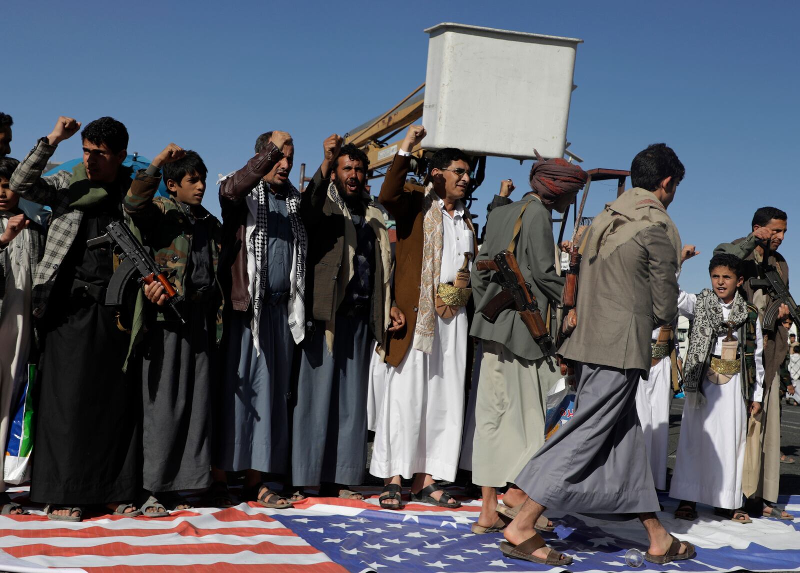 Houthi supporters step on an American flag during an anti-U.S and Israel rally in Sanaa, Yemen, Friday, Jan. 17, 2025. (AP Photo/Osamah Abdulrahman)