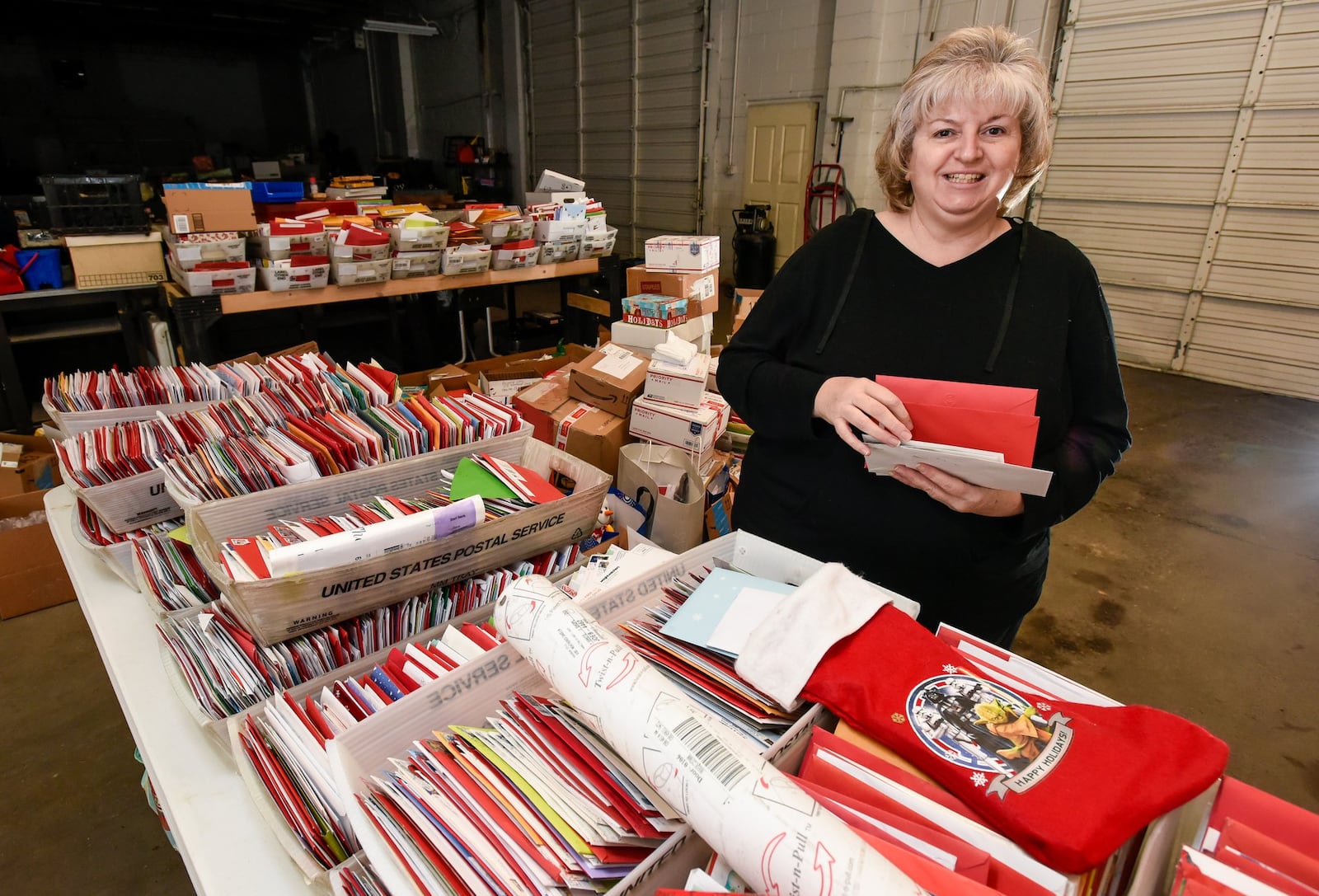 Alyson Little stands among an estimated 50,000 Christmas cards mailed to her grandson, Andrew Little, 8. Andrew, who is paralyzed him from the neck down, said he wanted just one thing for Christmas — Christmas Cards. NICK GRAHAM/STAFF