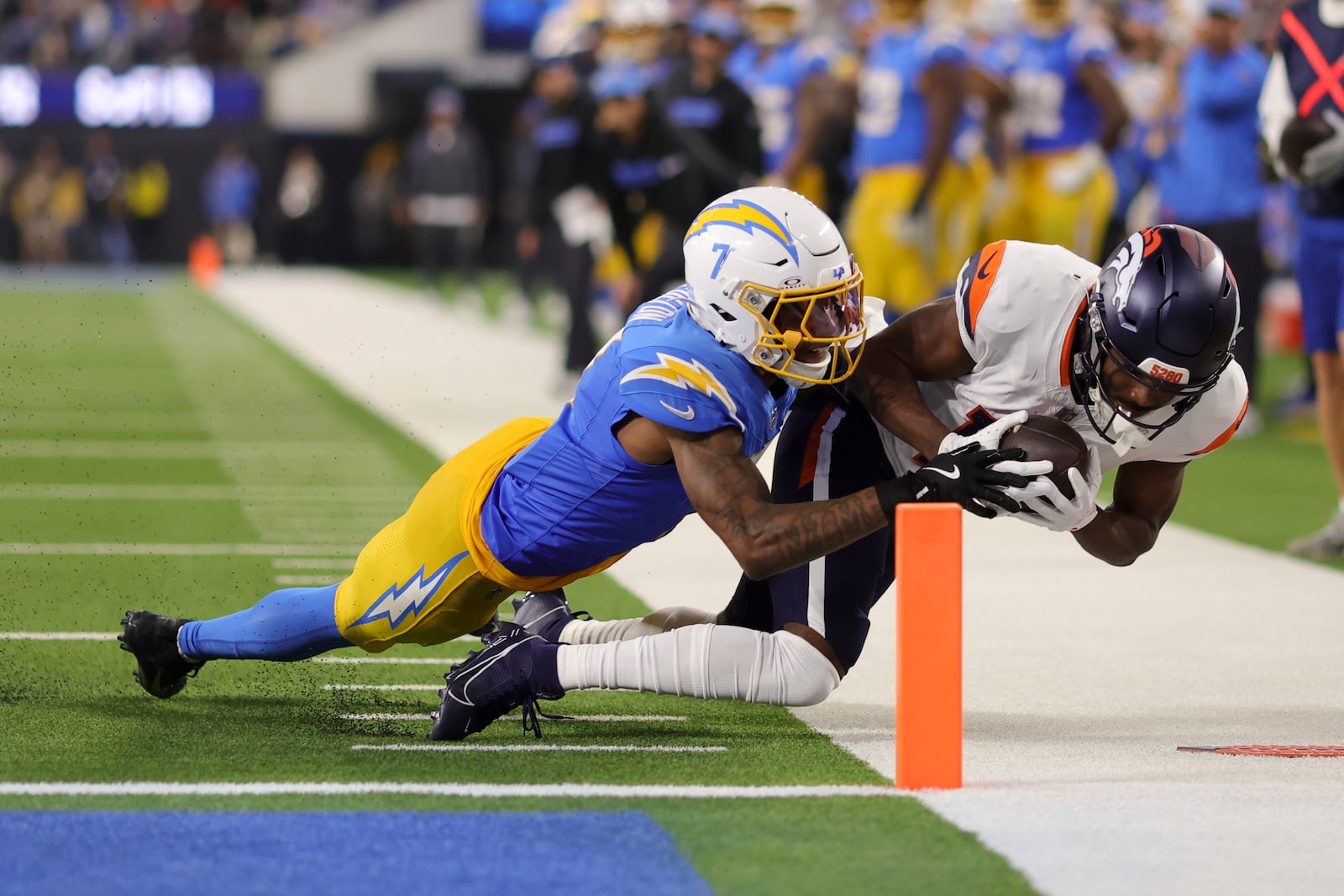 Denver Broncos wide receiver Marvin Mims Jr. (19) is tackled short of the goal line by Los Angeles Chargers cornerback Kristian Fulton (7) during the first half of an NFL football game Thursday, Dec. 19, 2024, in Inglewood, Calif. (AP Photo/Ryan Sun)