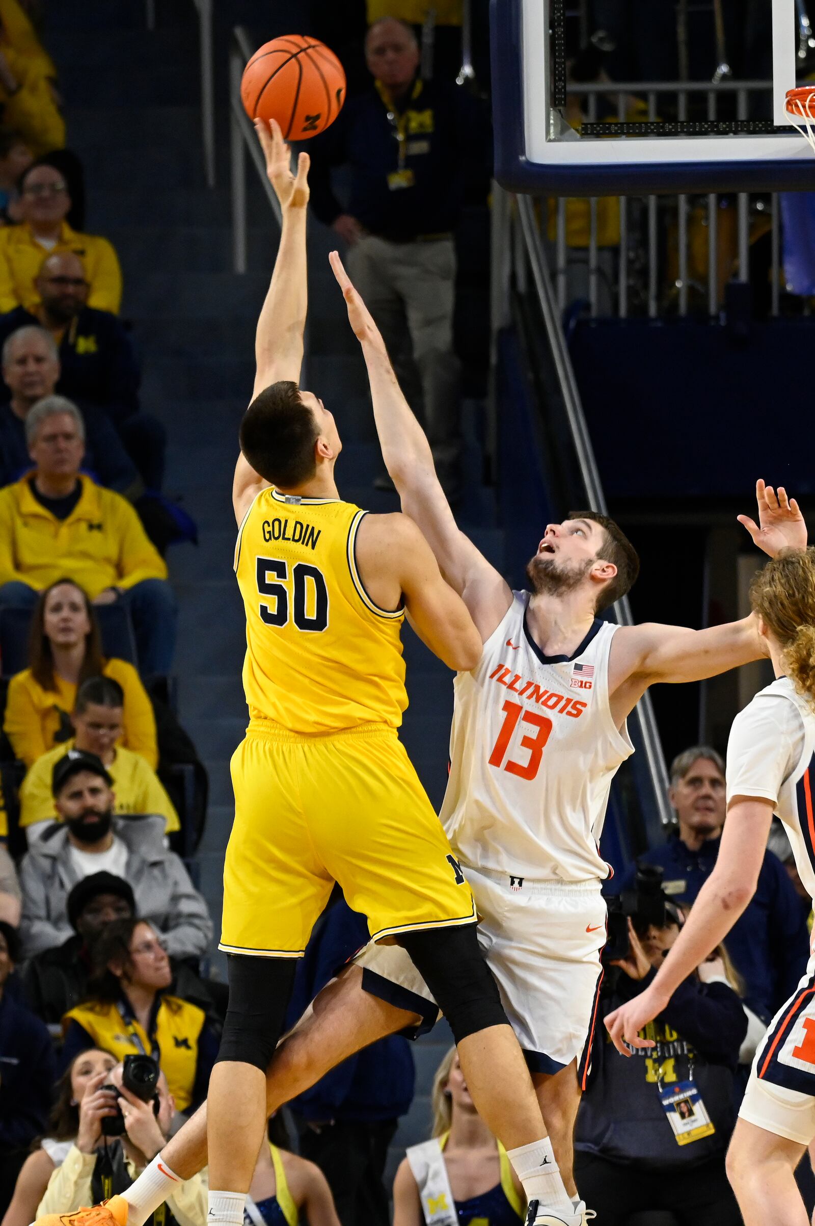 Michigan center Vladislav Goldin, left, shoots over Illinois center Tomislav Ivisic during the first half of an NCAA college basketball game, Sunday, March 2, 2025, in Ann Arbor, Mich. (AP Photo/Jose Juarez)