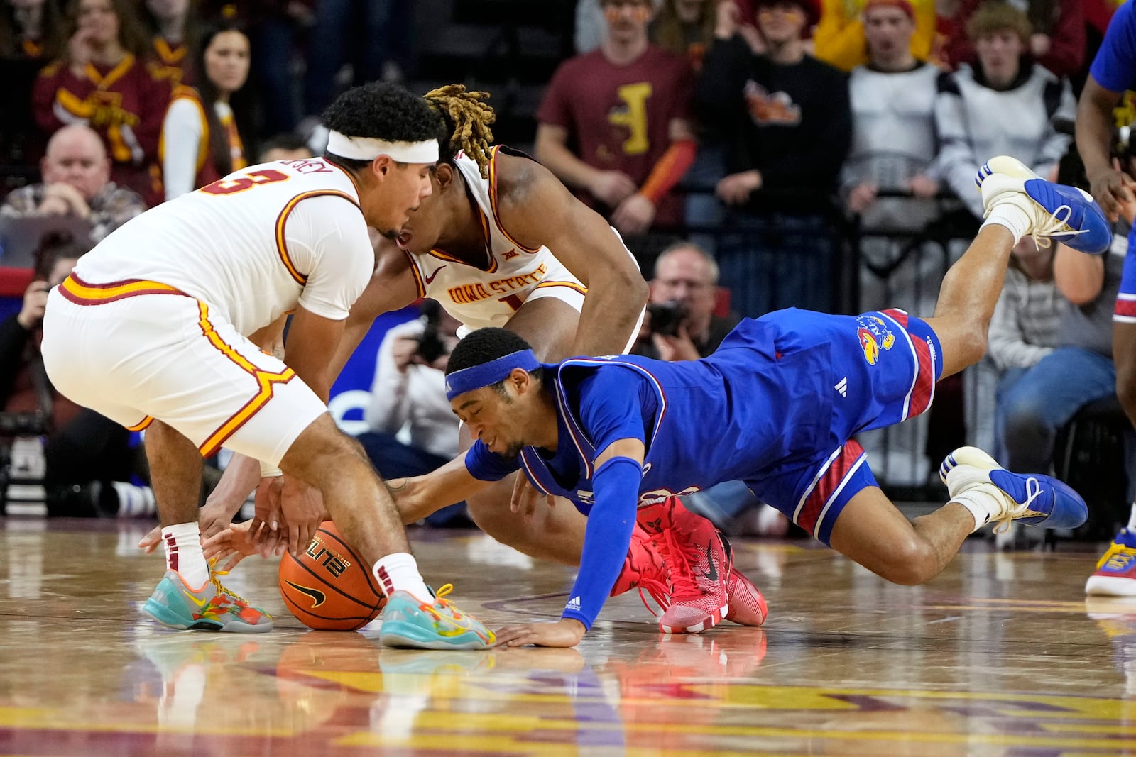 Kansas guard Dajuan Harris Jr., right, fights for a loose ball with Iowa State guard Tamin Lipsey, left, during the first half of an NCAA college basketball game Wednesday, Jan. 15, 2025, in Ames, Iowa. (AP Photo/Charlie Neibergall)