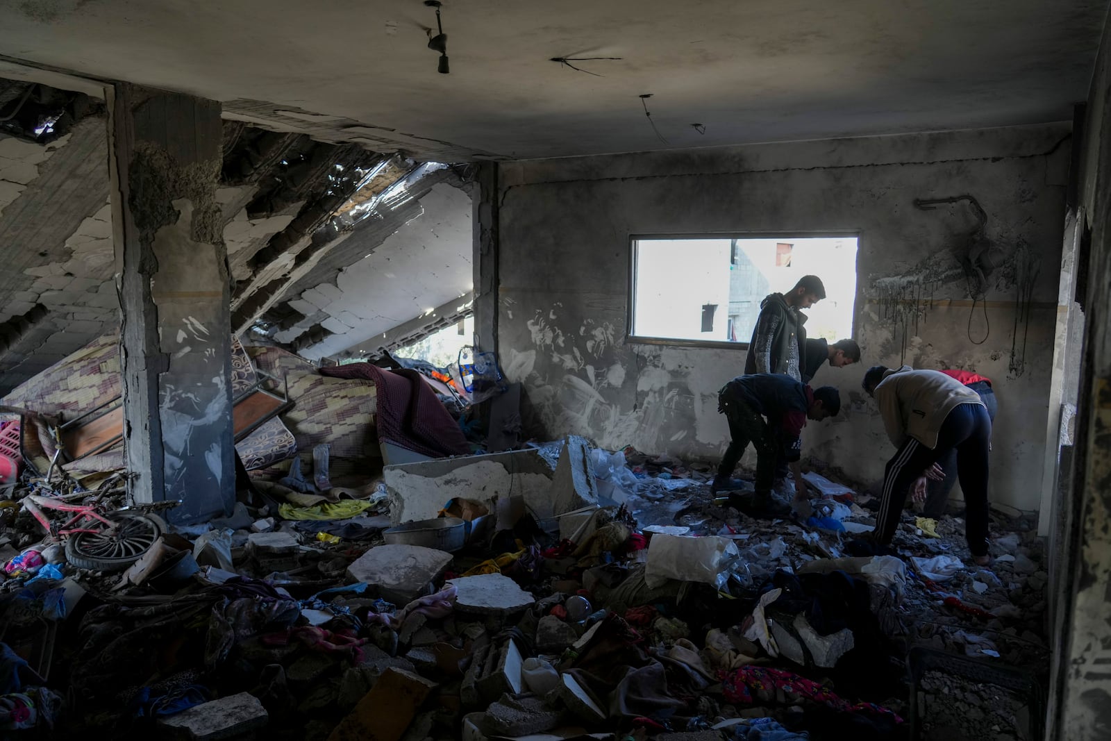 Palestinians inspect the damage at Al-Tabi'in School in central Gaza Strip following an Israeli airstrike, Tuesday, March 18, 2025. (AP Photo/Jehad Alshrafi)