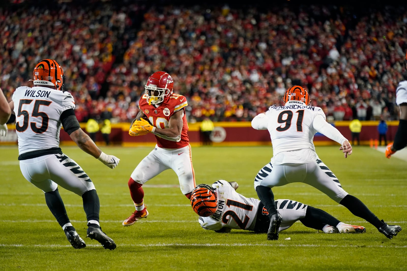 Kansas City Chiefs running back Isiah Pacheco (10) runs with the ball as Cincinnati Bengals linebacker Logan Wilson (55) and defensive end Trey Hendrickson (91) defend during the second half of an NFL football game Sunday, Dec. 31, 2023, in Kansas City, Mo. (AP Photo/Charlie Riedel)