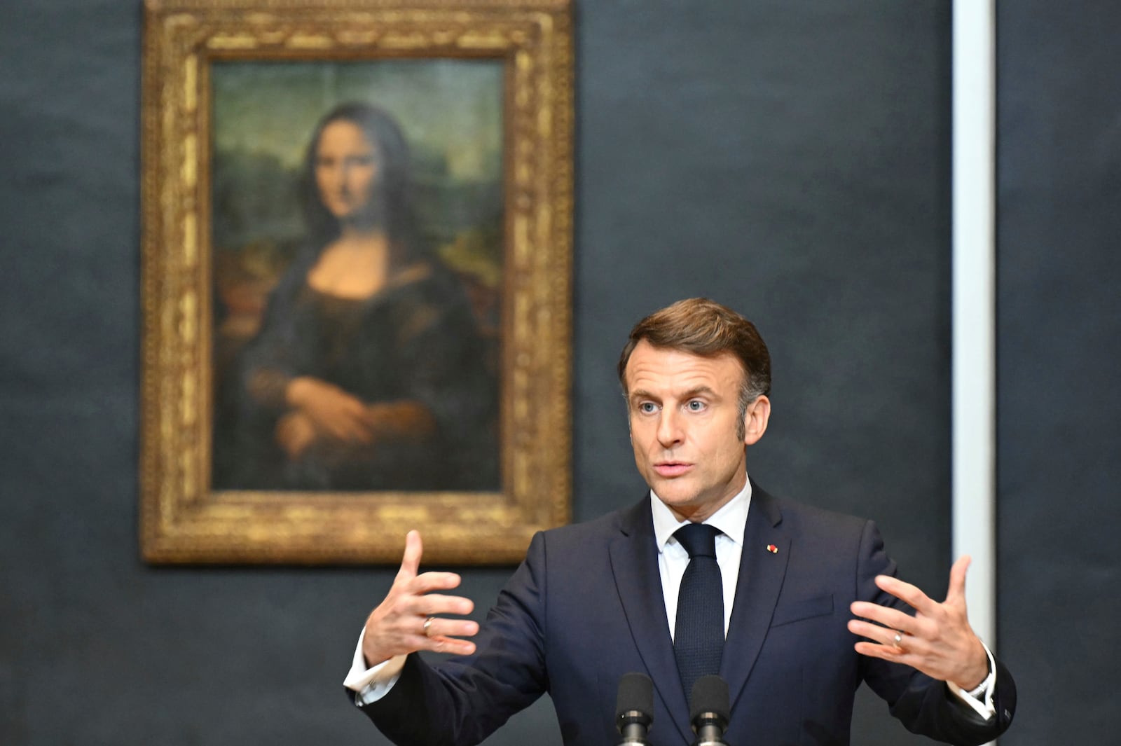 French President Emmanuel Macron gives a speech to announce a multi-year overhaul, long-term investments to modernize the Louvre museum, next to Leonardo da Vinci's painting of the Mona Lisa, at the Louvre Museum, Tuesday, Jan. 28, 2025 in Paris. ( Bertrand Guay, Pool via AP)