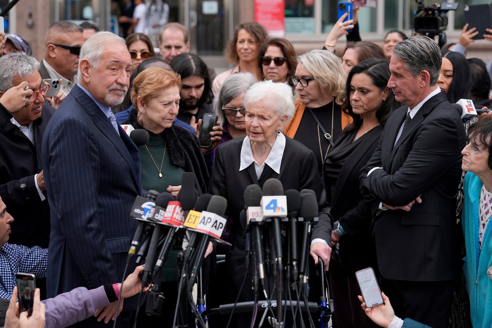 FILE - Joan Andersen VanderMolen, center, speaks to the media surrounded by family members of Erik and Lyle Menendez, and attorney Mark Geragos, far left, and attorney Bryan Freedman, far right, during a news conference after a hearing in Los Angeles, Monday, Nov. 25, 2024. (AP Photo/Damian Dovarganes, File)