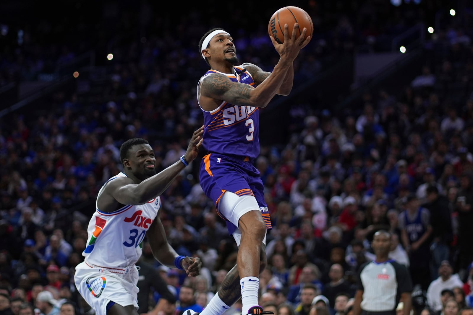 Phoenix Suns' Bradley Beal, right, goes up for a shot against Philadelphia 76ers' Adem Bona during the second half of an NBA basketball game, Monday, Jan. 6, 2025, in Philadelphia. (AP Photo/Matt Slocum)