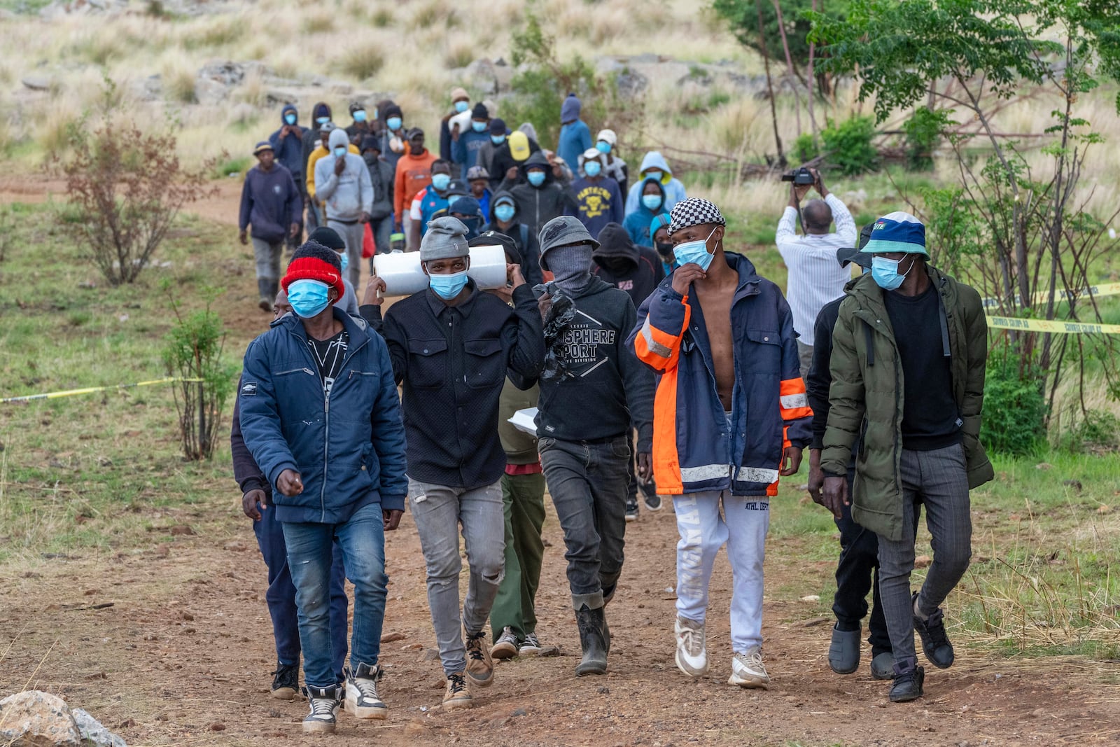 Volunteer rescue workers and community members leave a mine shaft where illegal miners are trapped in a disused mine in Stilfontein, South Africa, Thursday, Nov.14, 2024. (AP Photo/Jerome Delay)