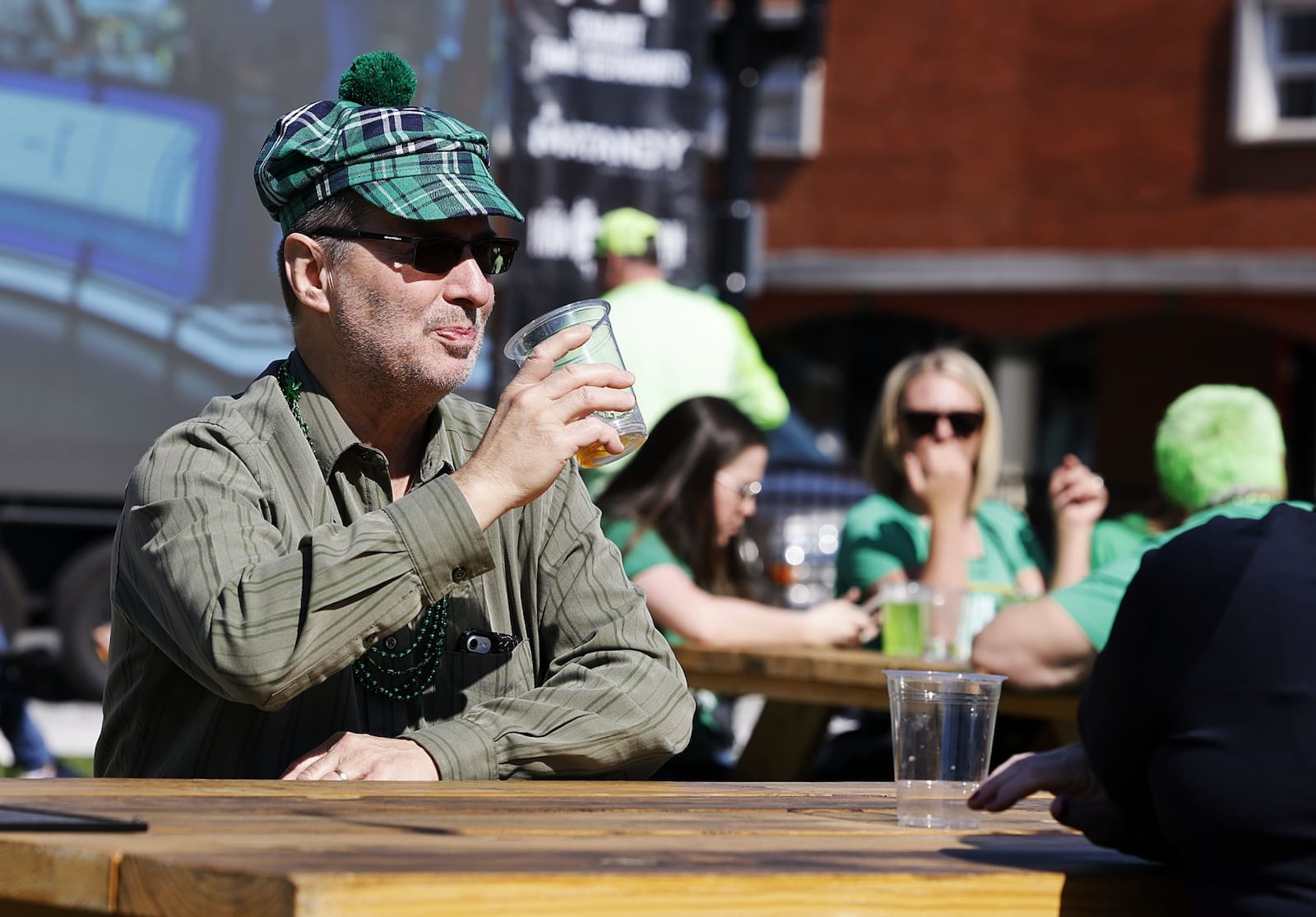 Bill Fiehrer soaks in the sun on St. Patrick's Day Thursday, March 17, 2022 at Hamilton’s Urban Backyard on Main Street in Hamilton. NICK GRAHAM/STAFF