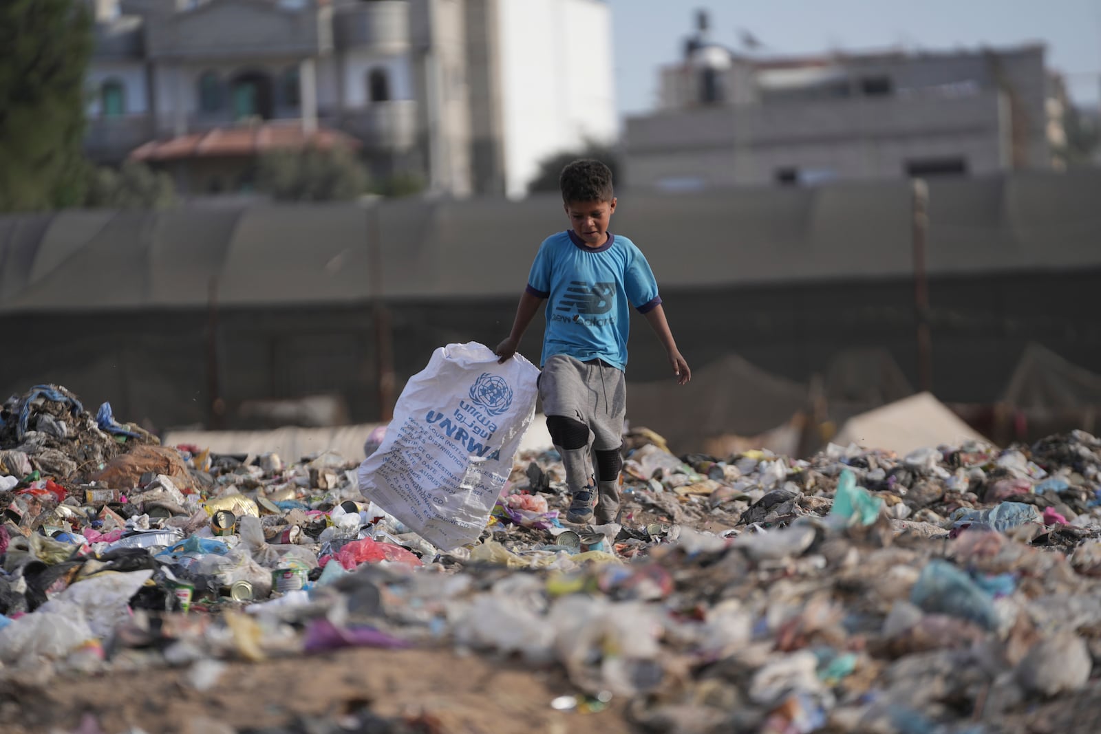 A Palestinian kid sorts through trash at a landfill in Zawaida, Gaza Strip, Sunday, Nov. 17, 2024. (AP Photo/Abdel Kareem Hana)