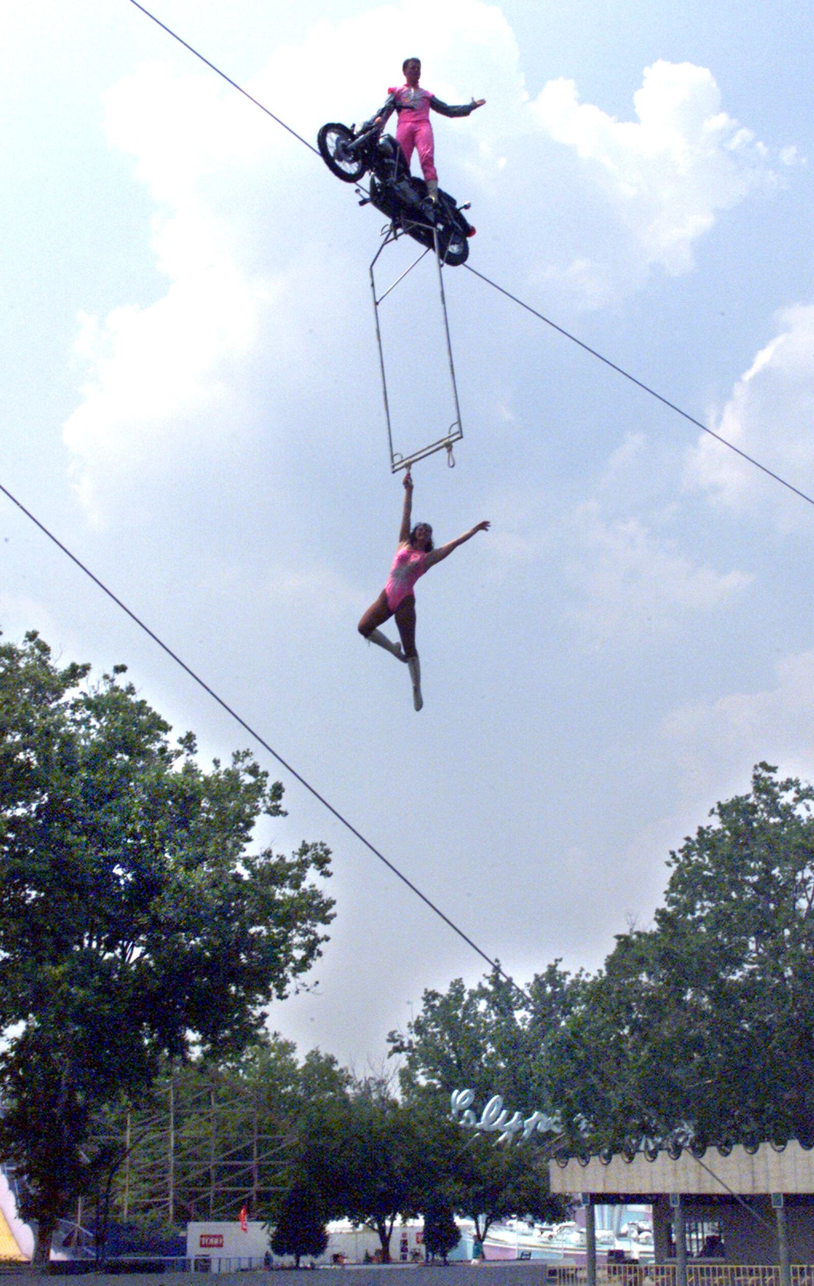 In 1999, Delilah Wallenda and her son Nikolas perform on a motorcycle attached to a wire over the lake at Americana Amusement Park.