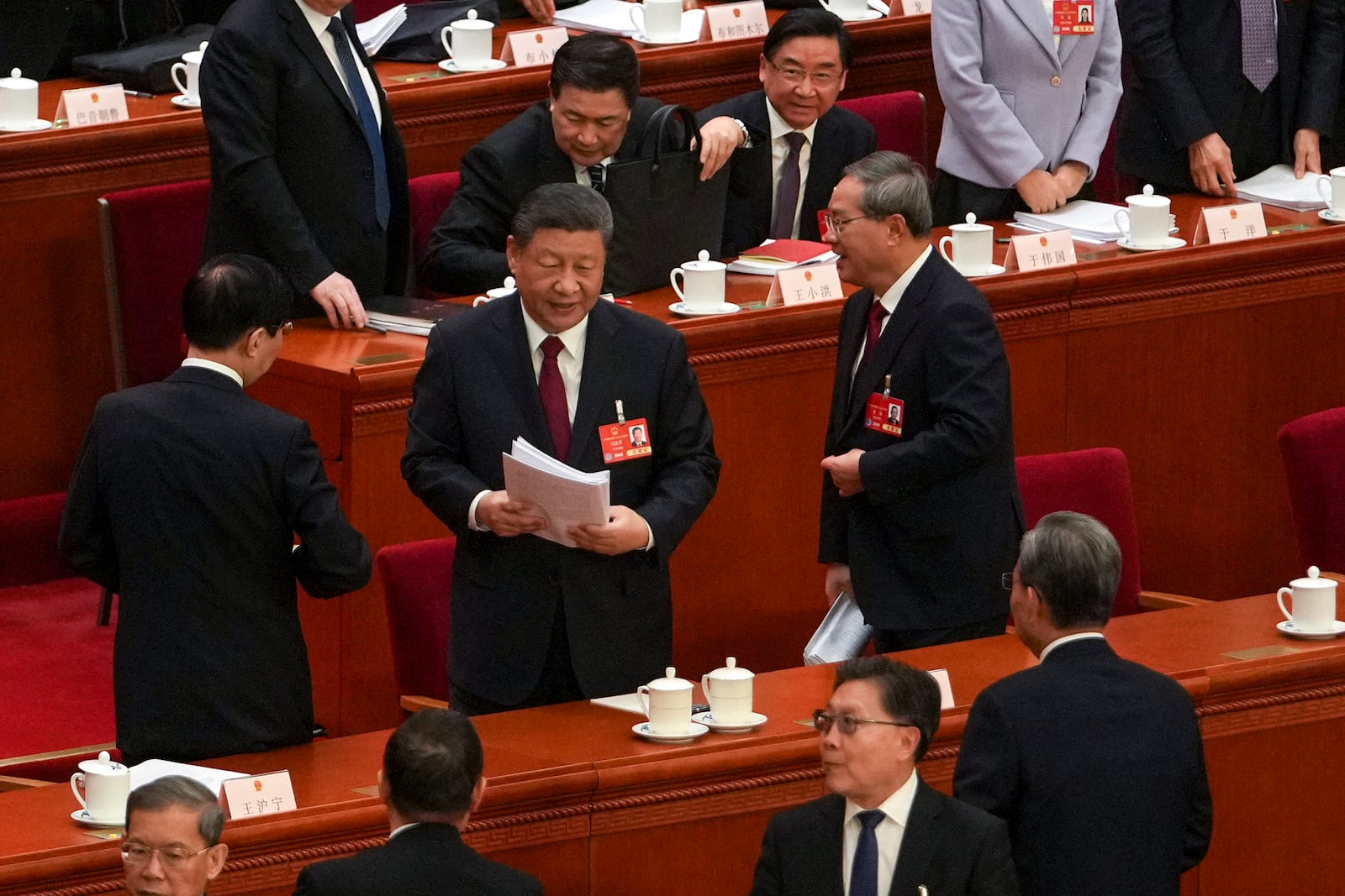 Chinese President Xi Jinping, center, and his Premier Li Qiang, left, prepare to leave the hall after attending the opening session of the National People's Congress held at the Great Hall of the People in Beijing, Wednesday, March 5, 2025. (AP Photo/Andy Wong)