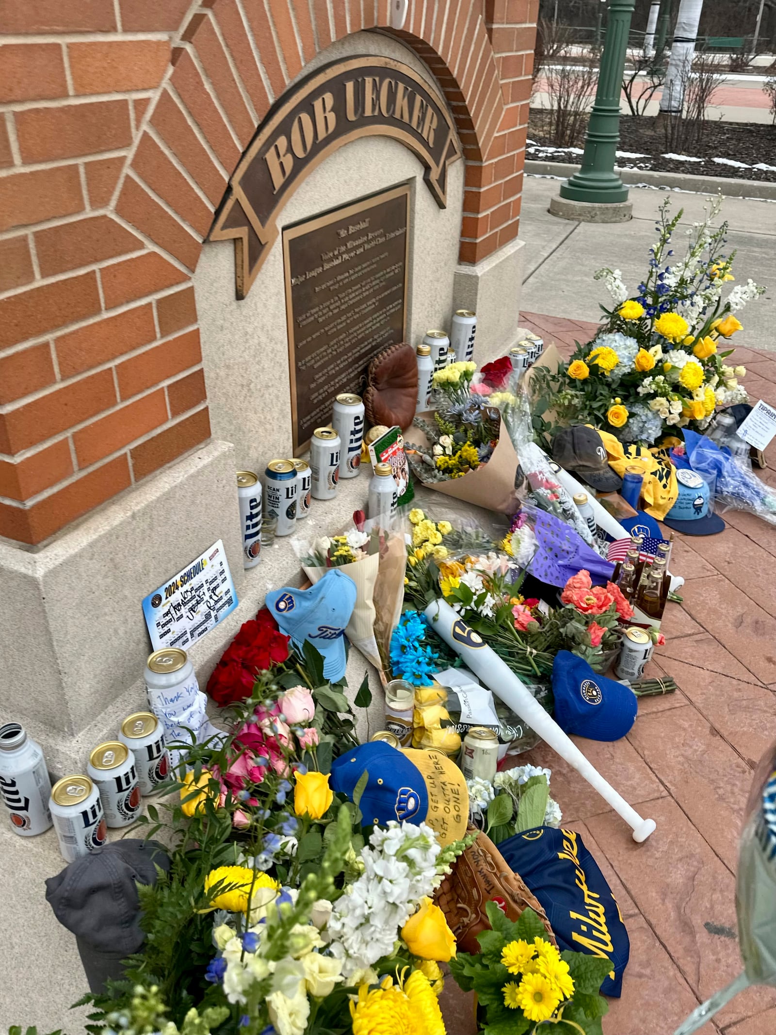 Items are left at the base of a statue of Bob Uecker outside American Family Field in Milwaukee, Thursday, Jan. 16, 2025. (AP Photo/Steve Megargee)