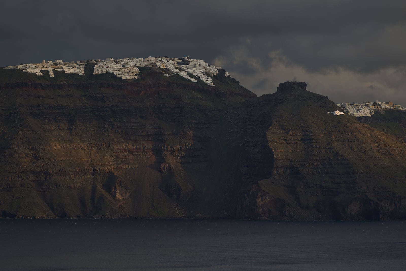 The main town of Fira is seen from across a bay on the earthquake-struck island of Santorini, Greece, Tuesday, Feb. 4, 2025. (AP Photo/Petros Giannakouris)