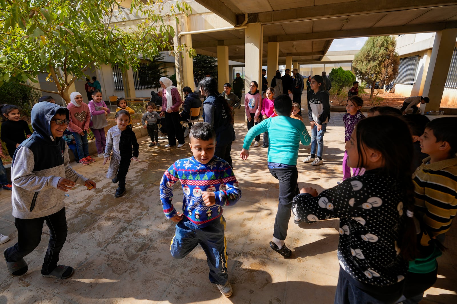 Displaced children, who fled Baalbek city and the nearby towns of Douris and Ain Bourday with their families amid the ongoing Hezbollah-Israel war, play at a school being used as a shelter, in Deir Al-Ahmar, east Lebanon, Thursday, Oct. 31, 2024. (AP Photo/Hassan Ammar)