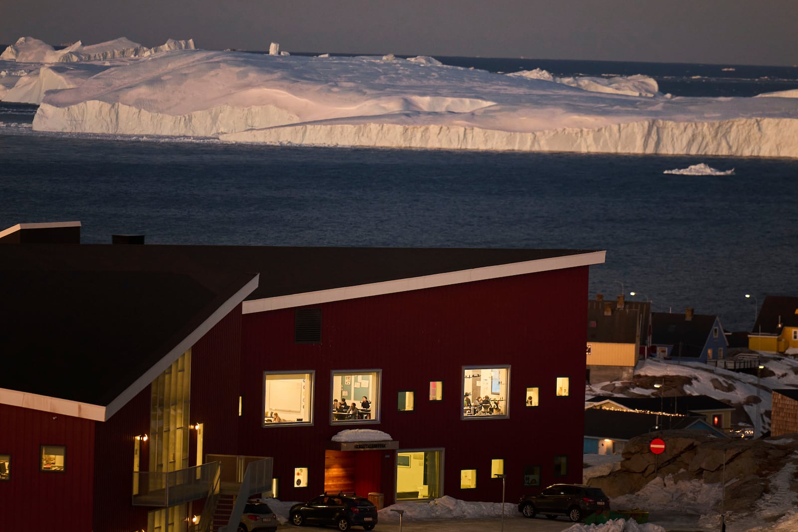 Public school pupils are seen inside their classrooms next to the large icebergs in the city of Ilulissat, Greenland, Wednesday Feb. 19, 2025. (AP Photo/Emilio Morenatti)