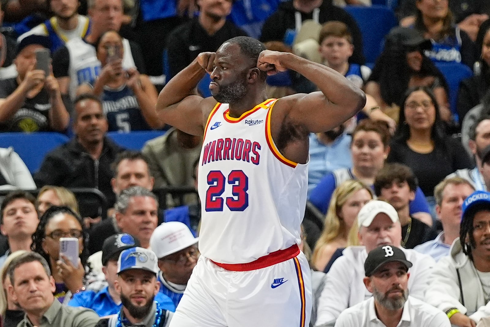 Golden State Warriors forward Draymond Green (23) flexes after making a shot and drawing a foul during the first half of an NBA basketball game against the Orlando Magic, Thursday, Feb. 27, 2025, in Orlando, Fla. (AP Photo/John Raoux)