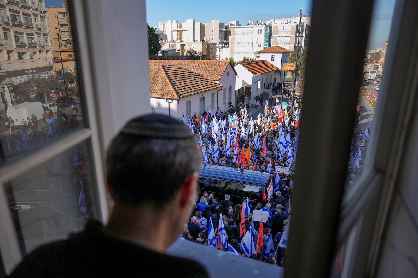 Mourners attend the funeral procession of slain hostages Shiri Bibas and her two children, Ariel and Kfir, in Rishon Lezion, Israel, Wednesday, Feb. 26, 2025. The mother and her two children were abducted by Hamas on Oct. 7, 2023, and their remains were returned from Gaza to Israel last week as part of a ceasefire agreement with Hamas. (AP Photo/Ariel Schalit)